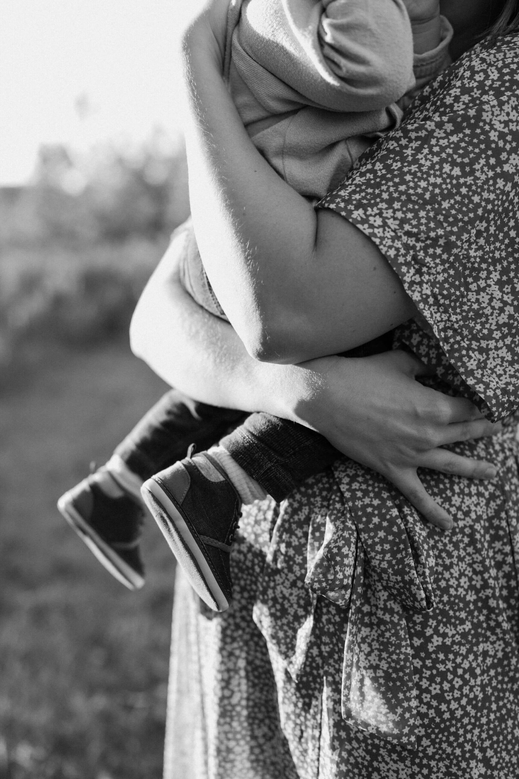 a close up black and white image of a mother holding her infant son