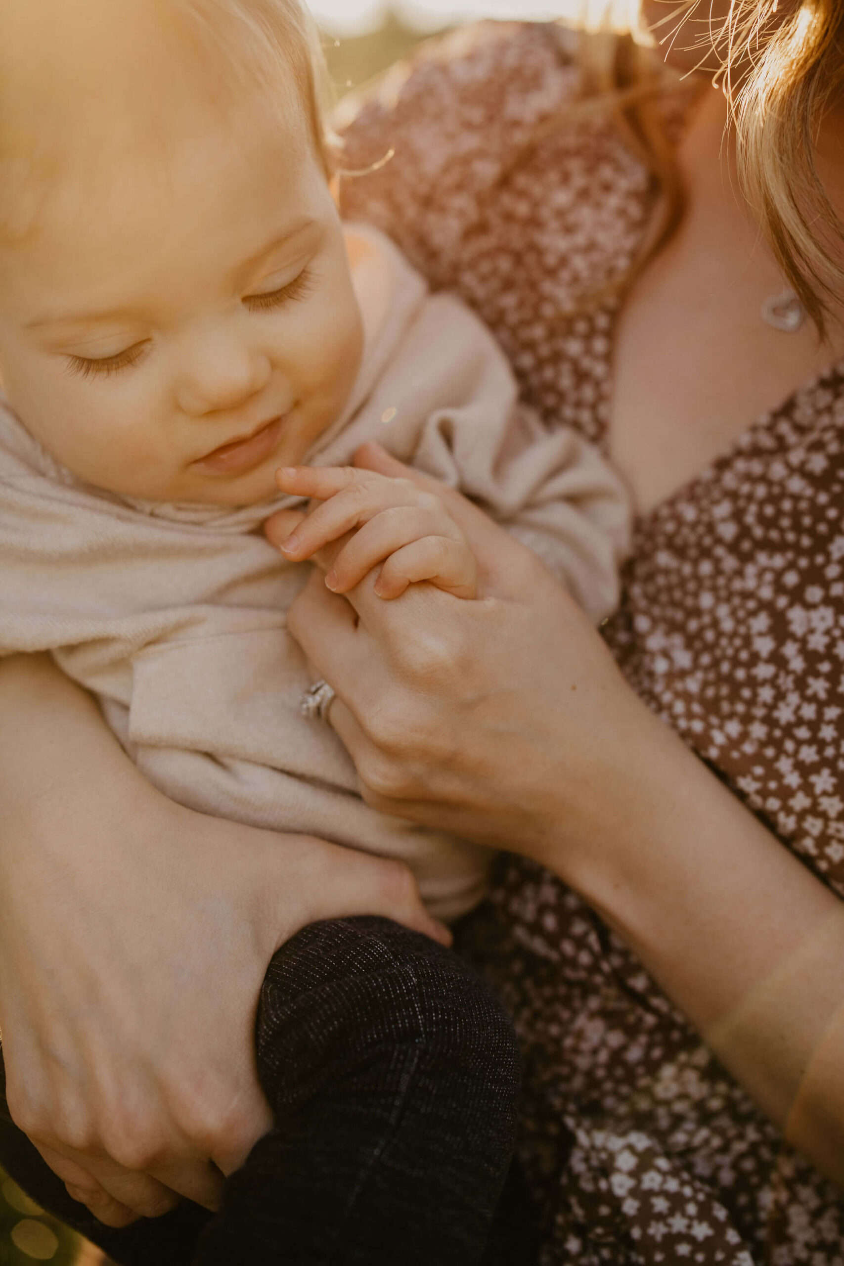 a close up image of a mother holding her one year old son's hand