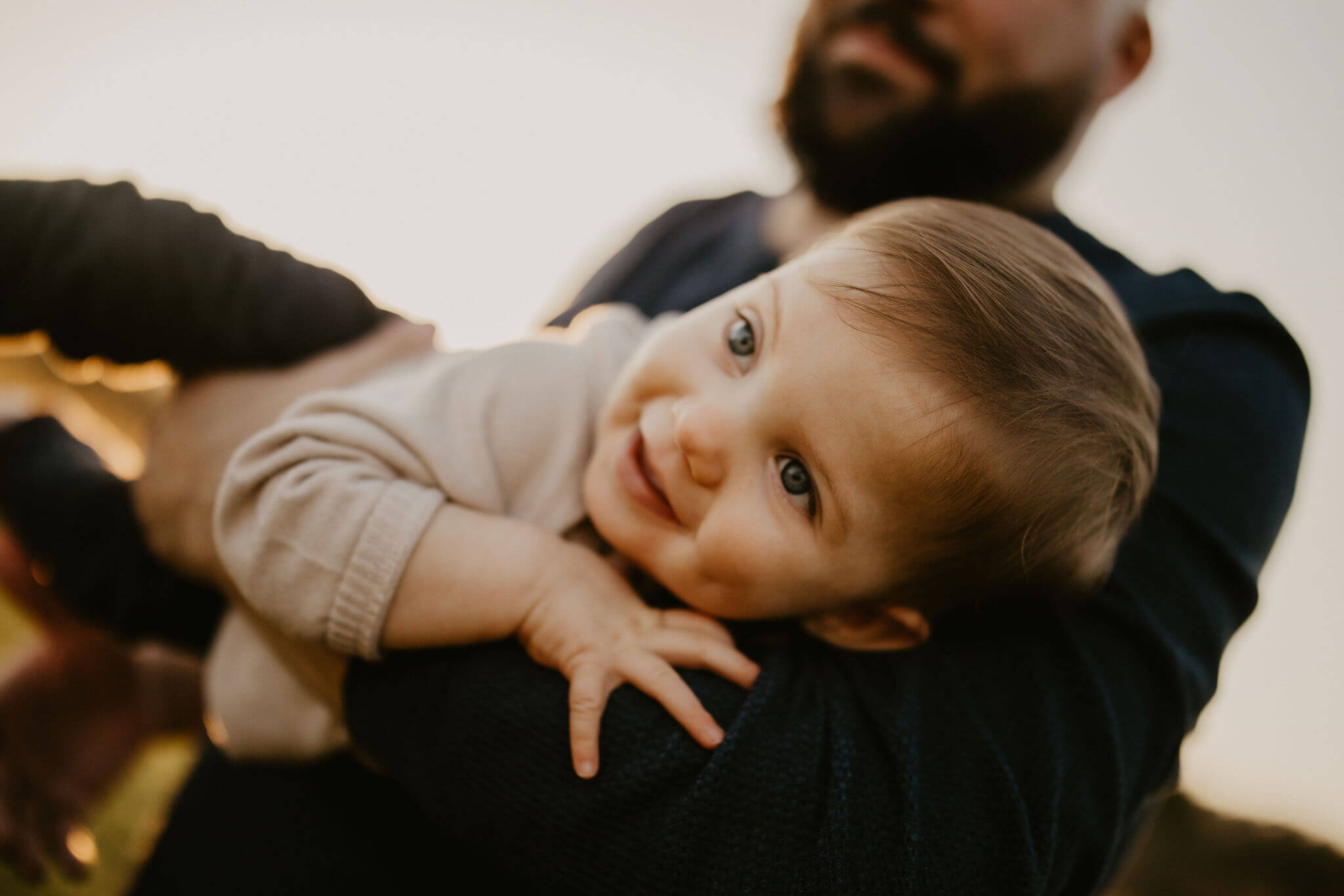 a young boy smiling in his father's arms