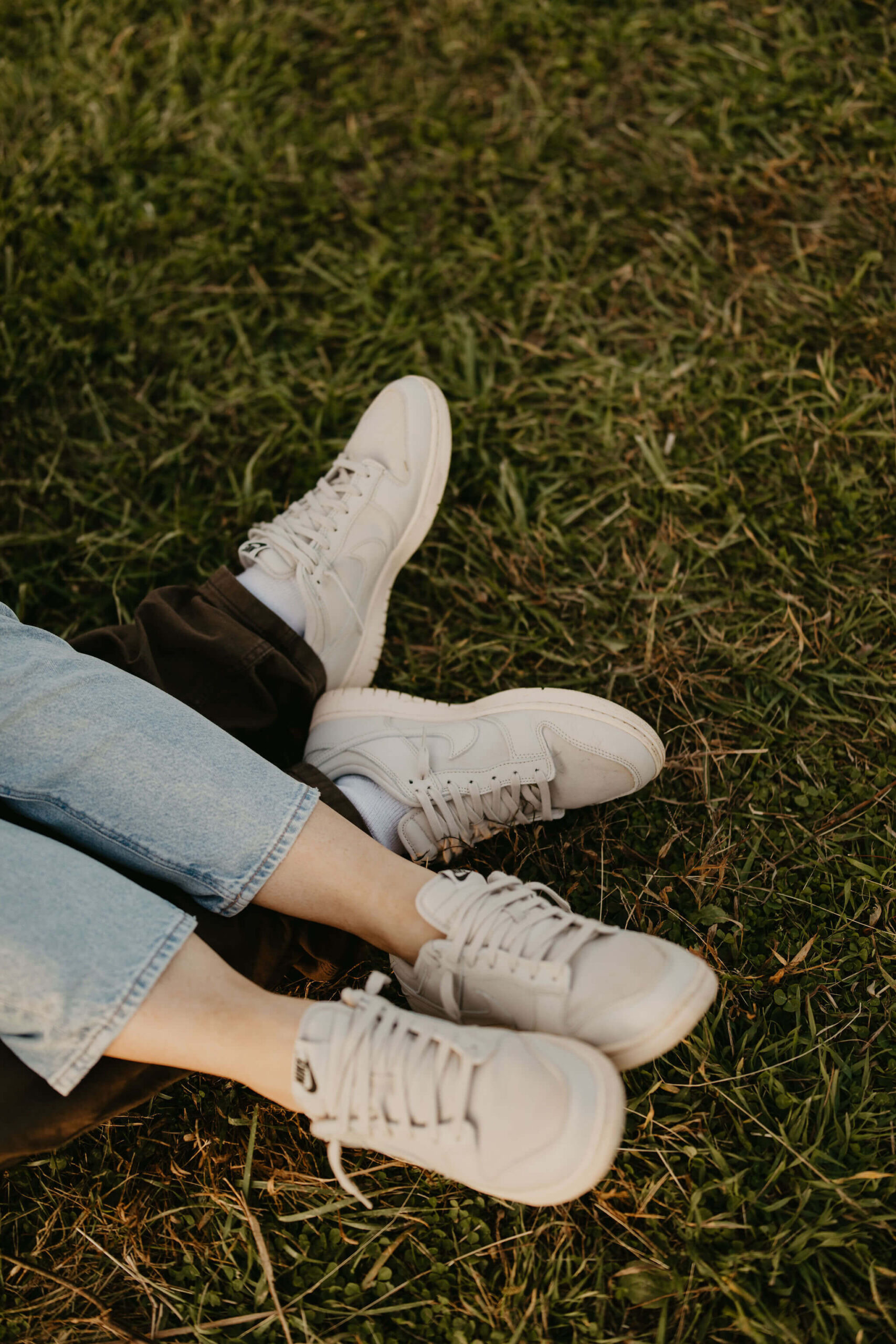 close up image of a couple wearing matching white sneakers