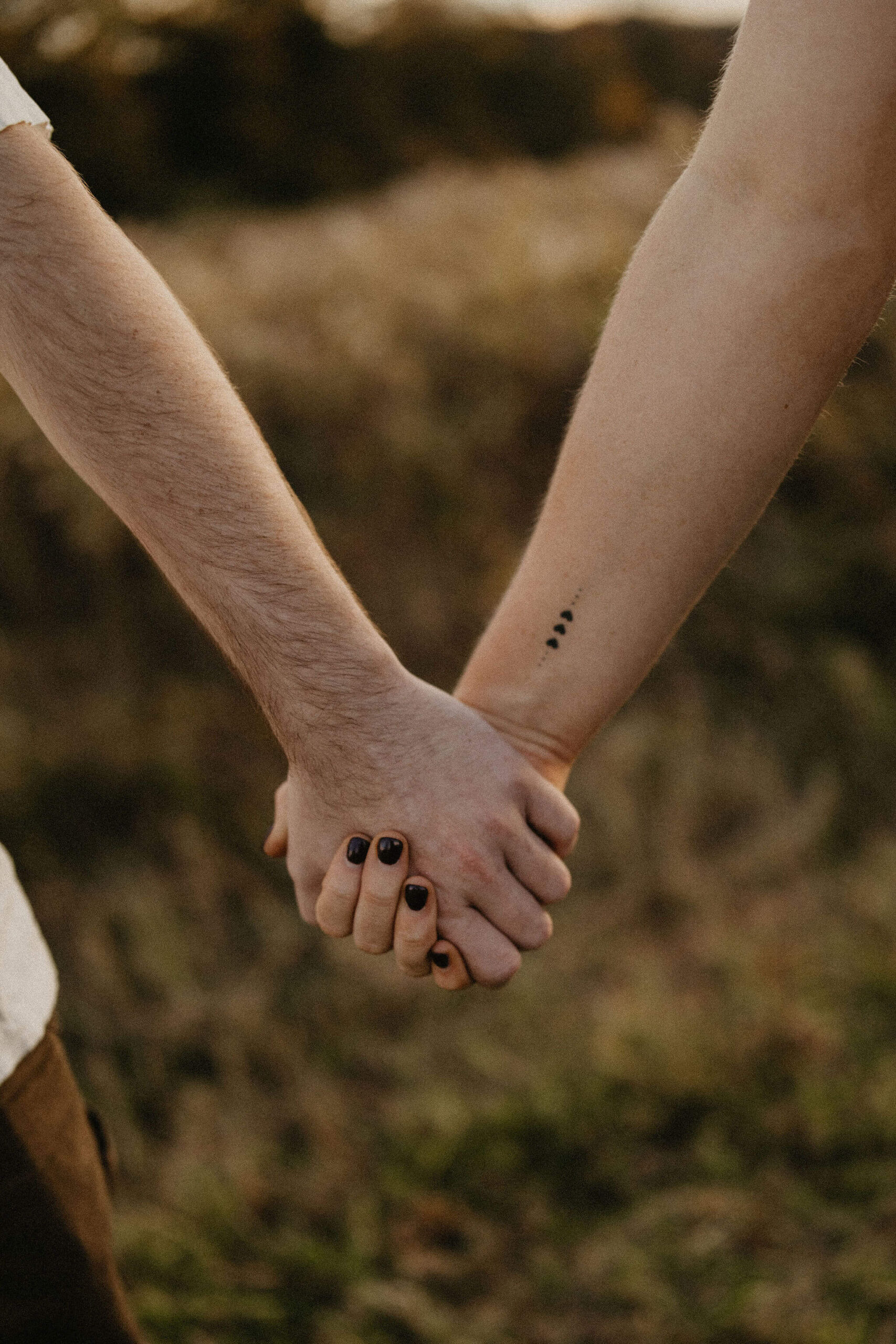 a close up image of a couple holding hands