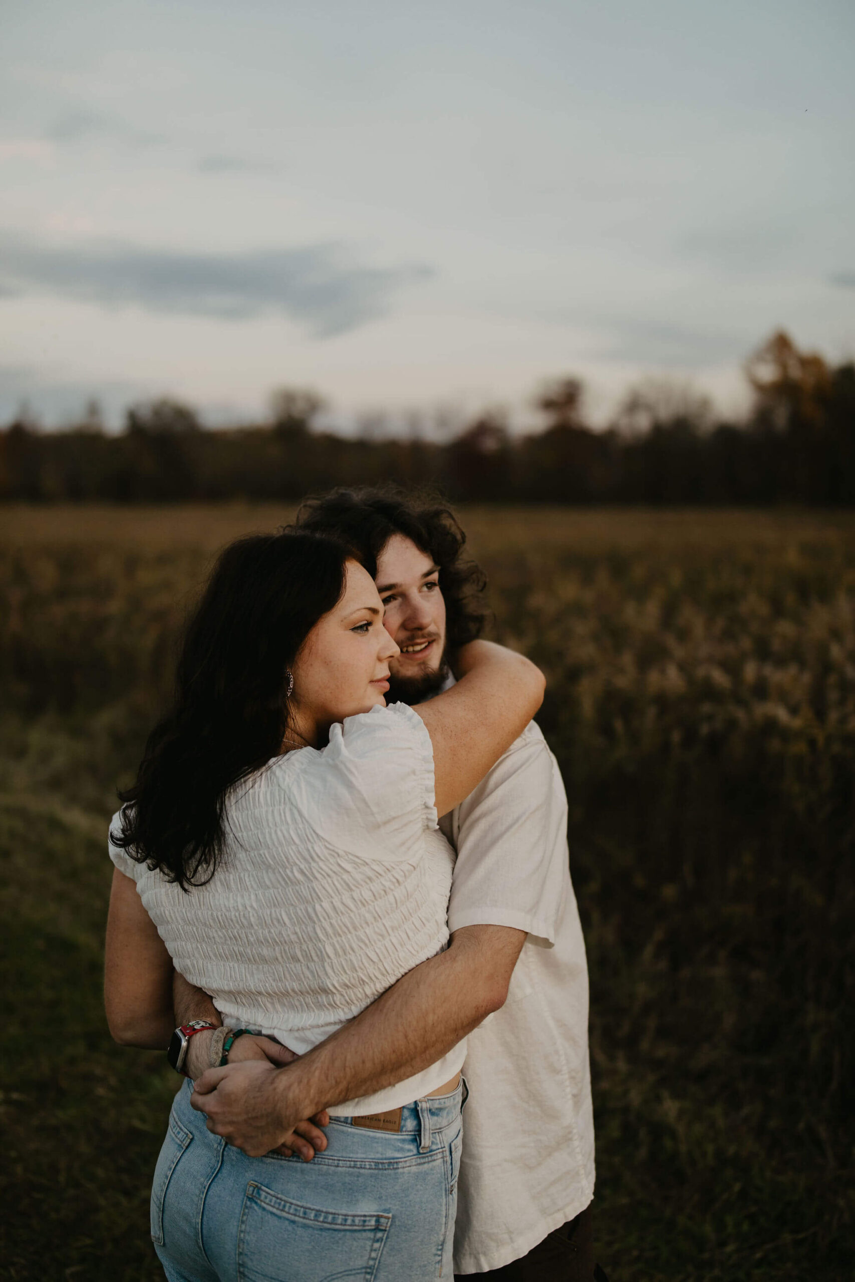 a young couple watching the moon rise during blue hour