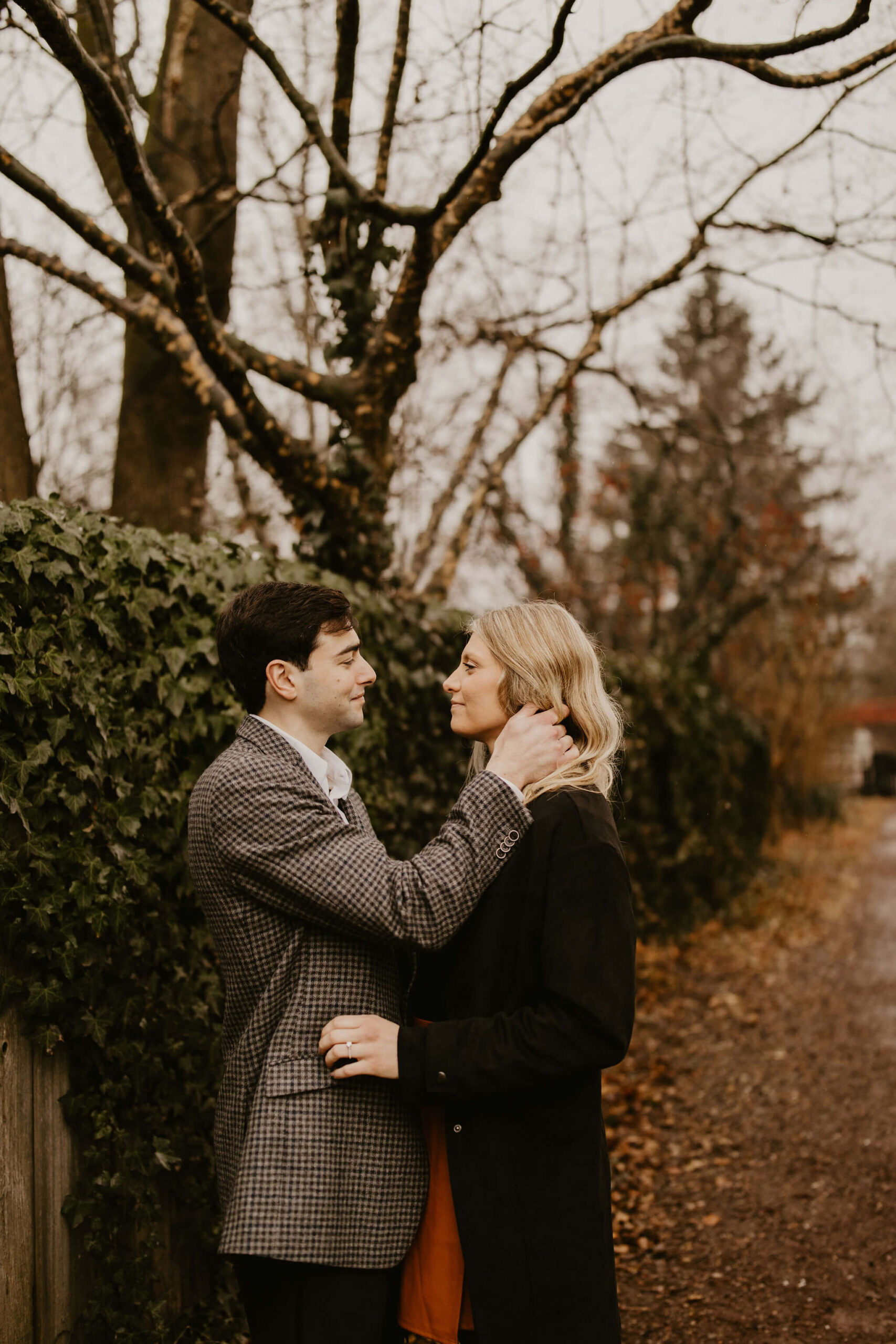 man pushing a woman's blonde hair behind her ear, looking at each other and smiling softly