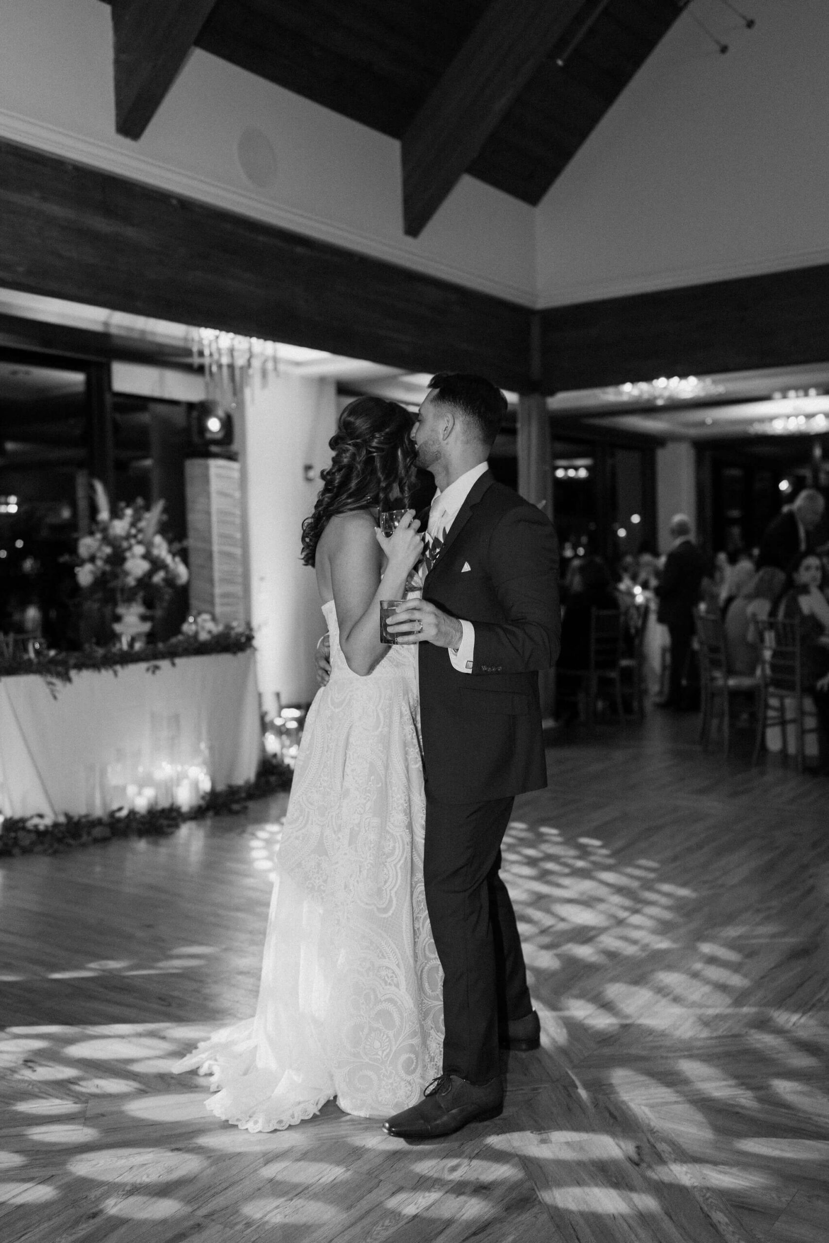 black and white image of a bride and groom embracing on the dance floor