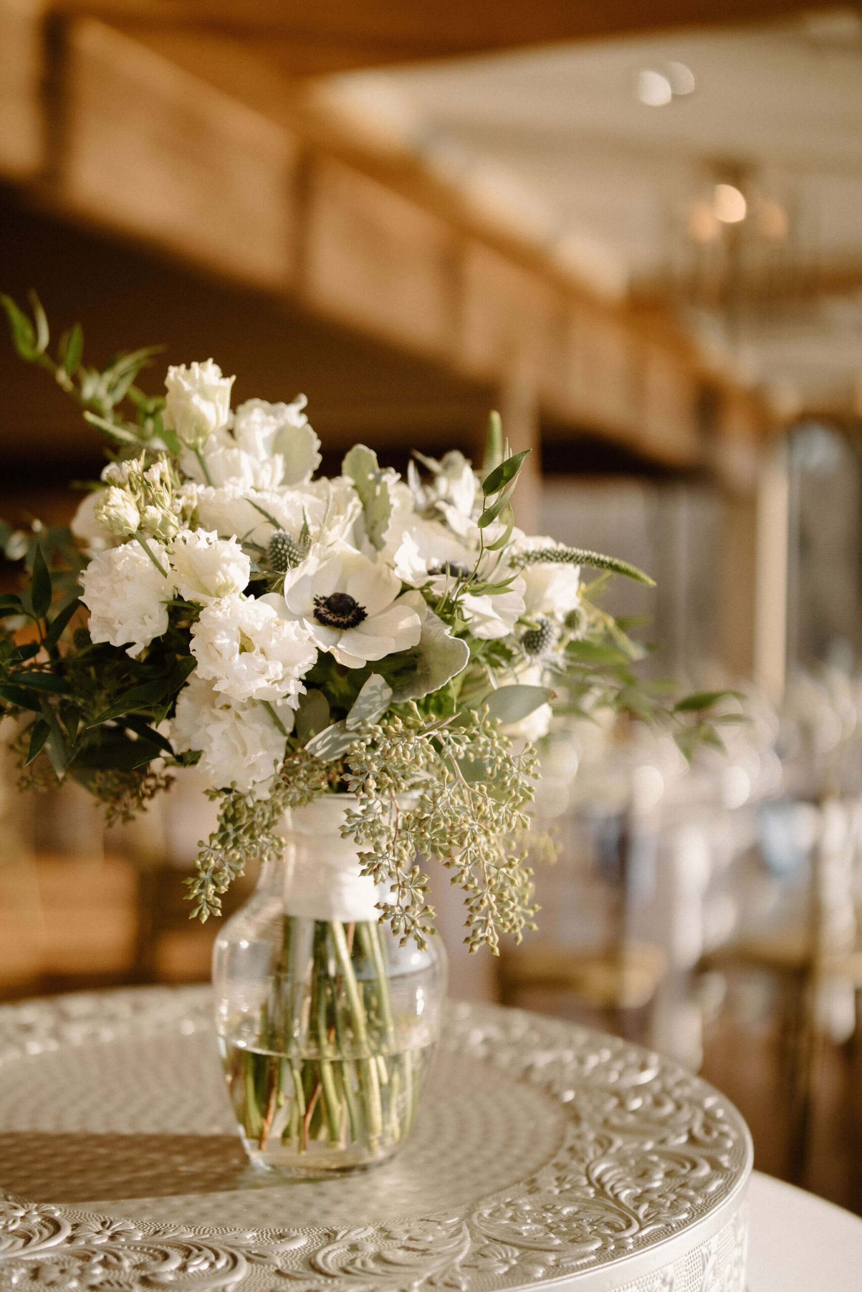 bridal bouquet with lots of greenery and eucalyptus, thistles, white roses, and white poppies