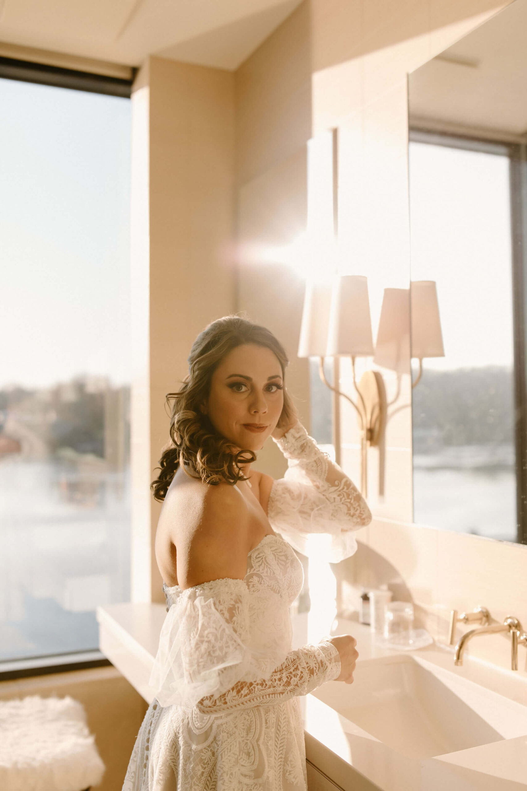 the bride looking over her shoulder toward the camera, fixing her hair