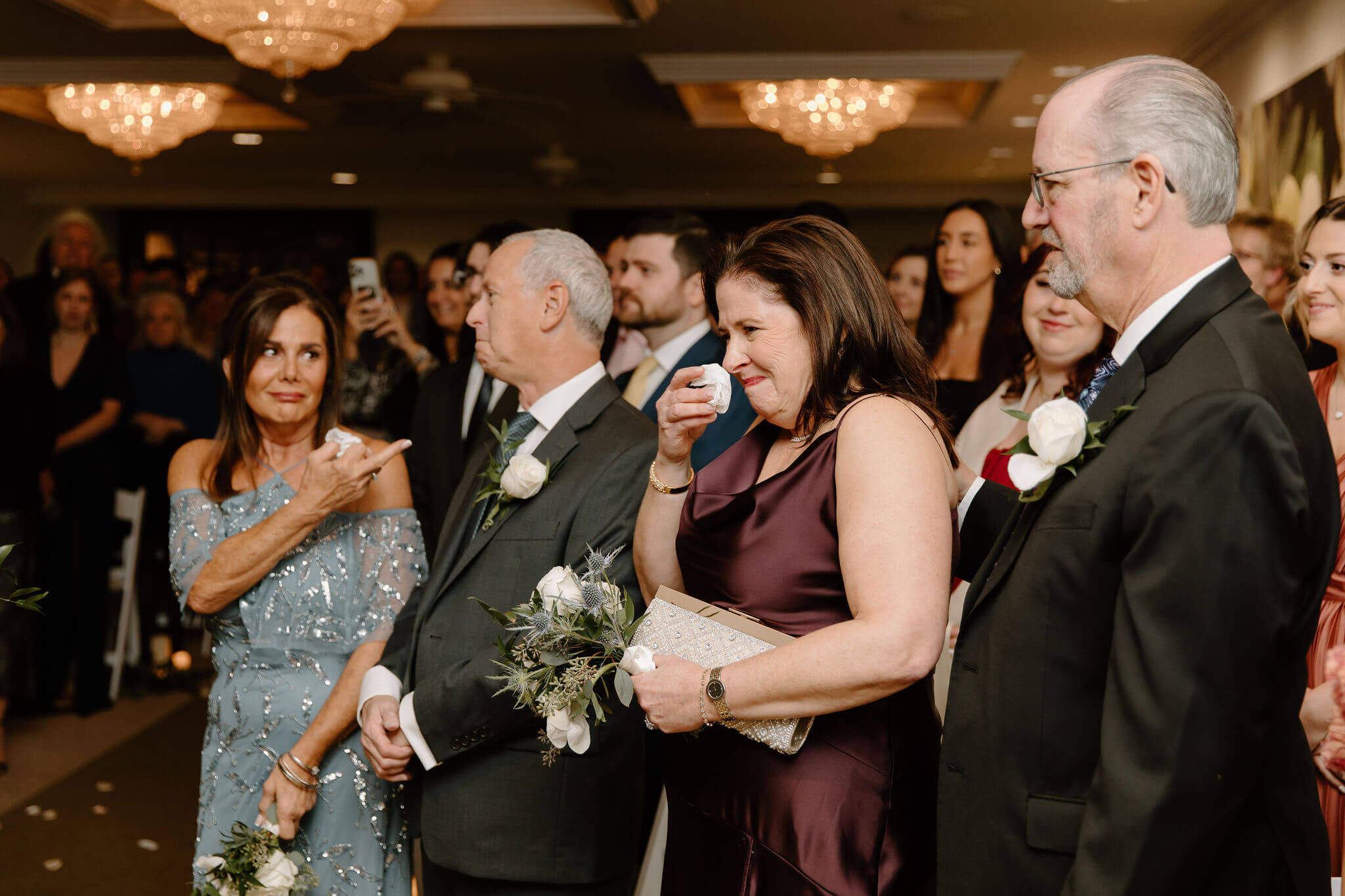 groom's mother and stepmother emotional during a wedding ceremony