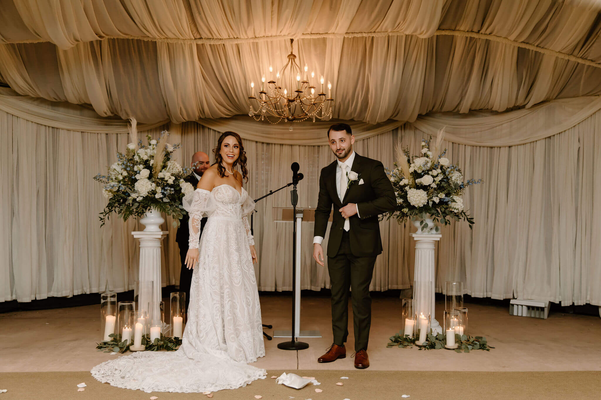 bride and groom about to break the glass in a Jewish wedding ceremony, looking toward their guests in anticipation