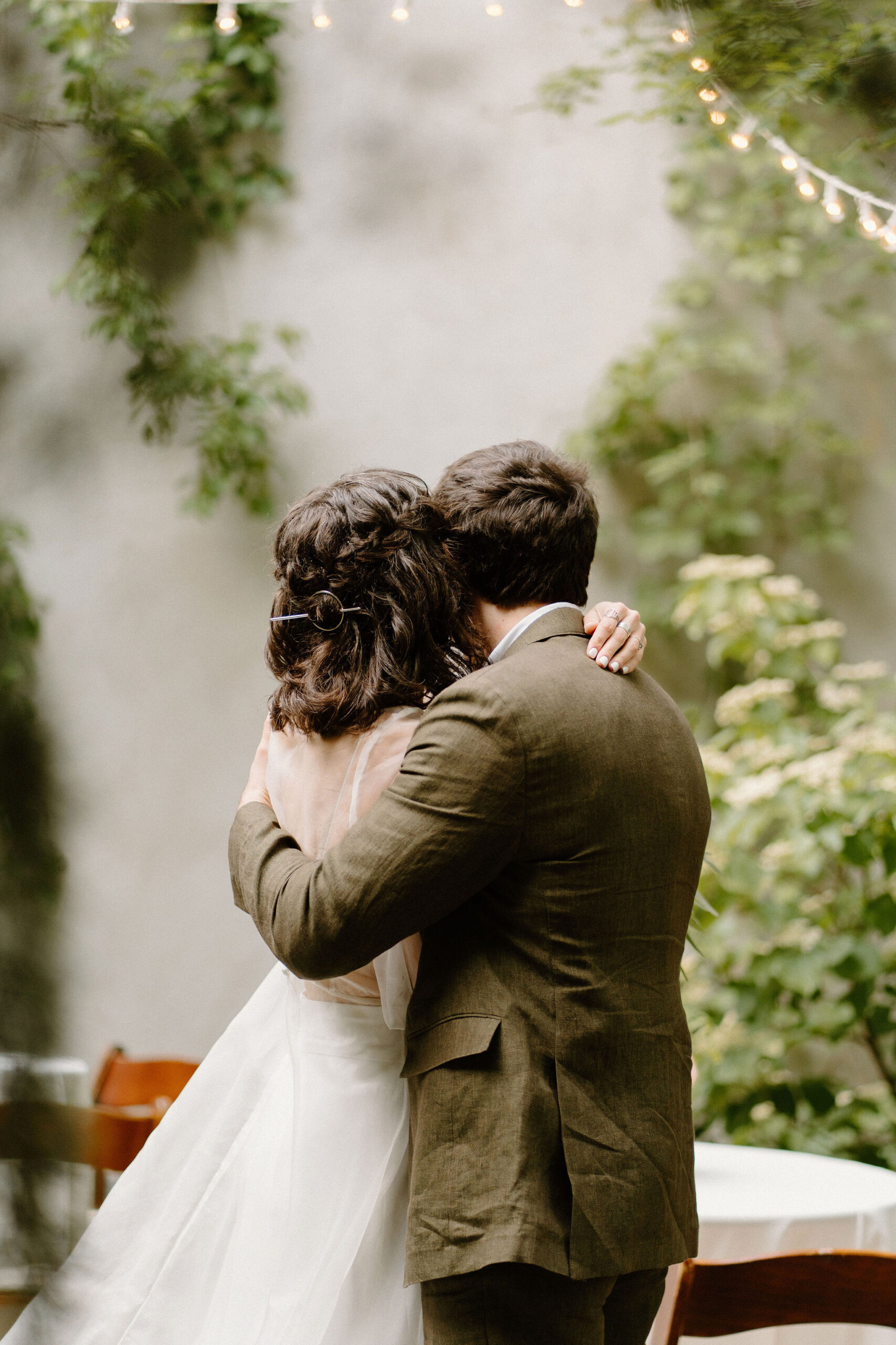 bride and groom embracing after their wedding ceremony, both looking away from camera