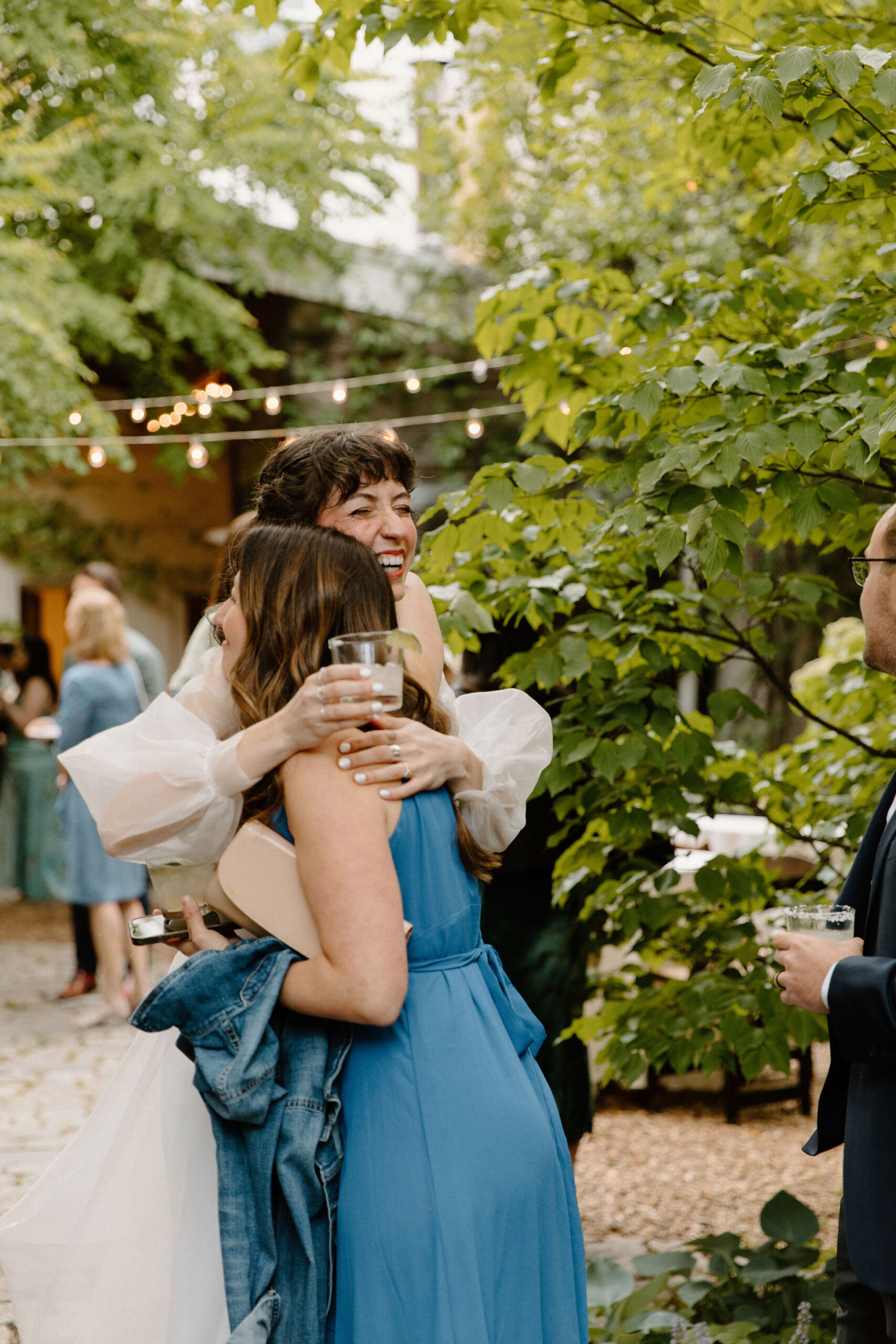 bride smiling as she embraces a guest