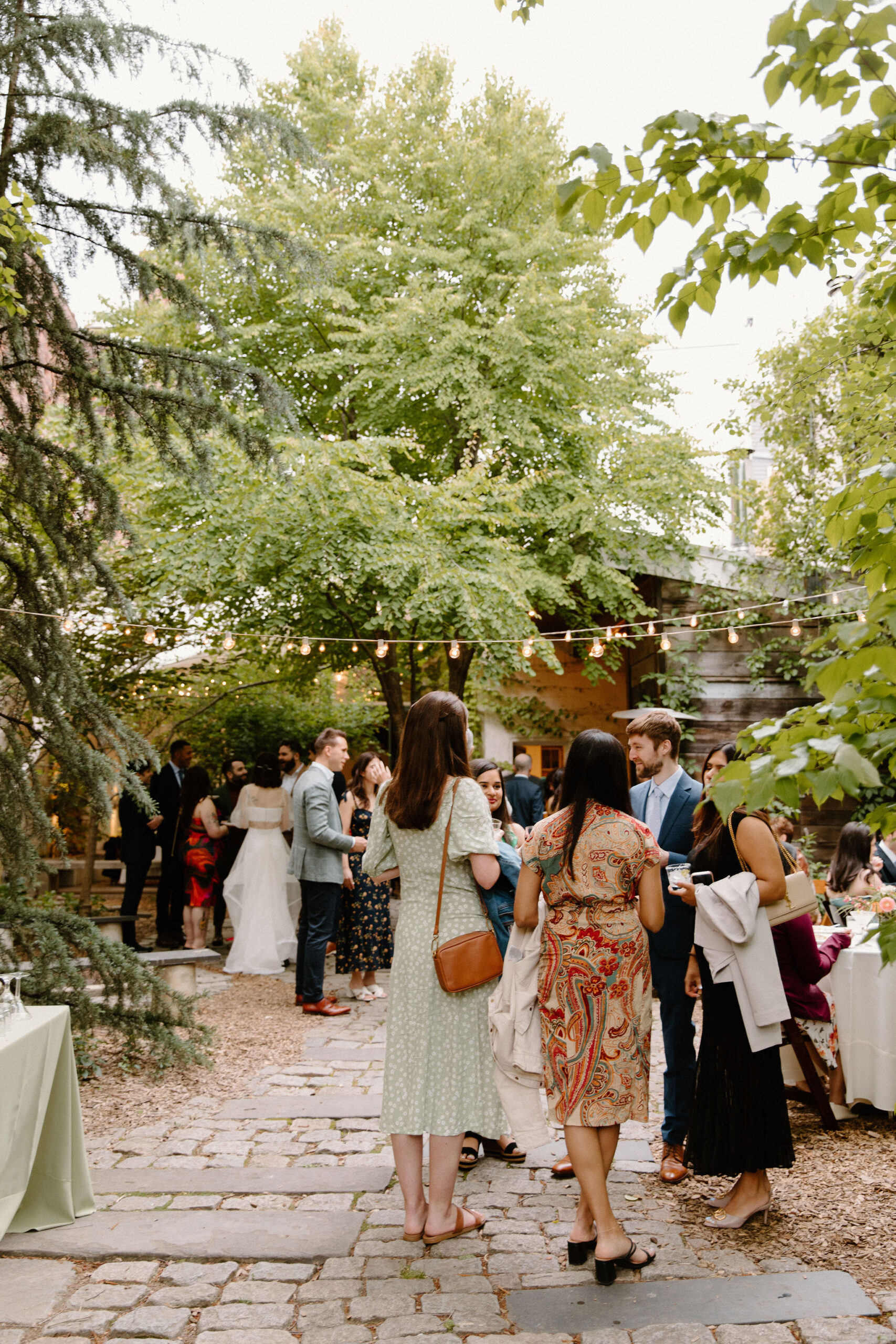 wide image of guests mingling in a courtyard cocktail hour