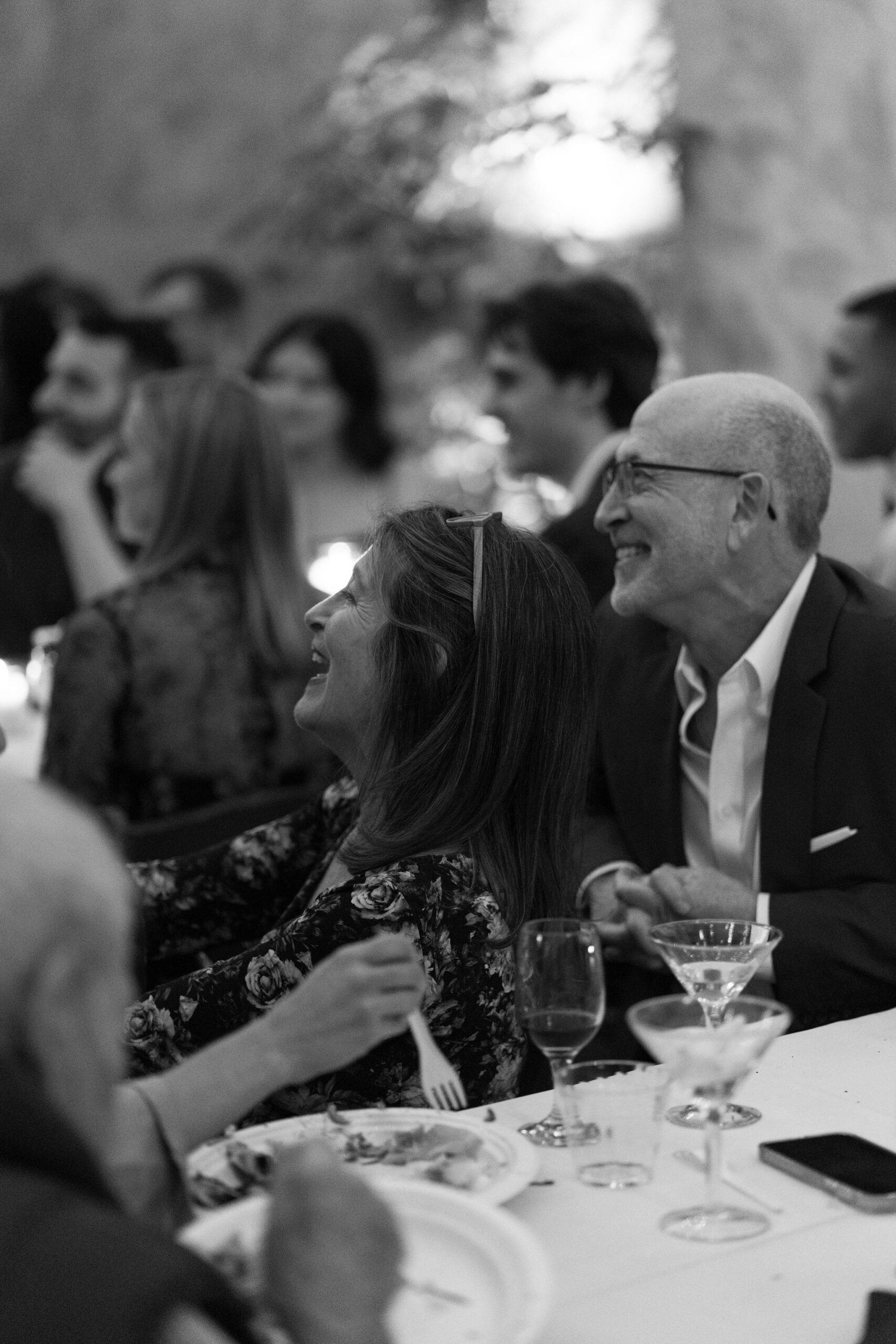 black and white image of guests laughing during speeches