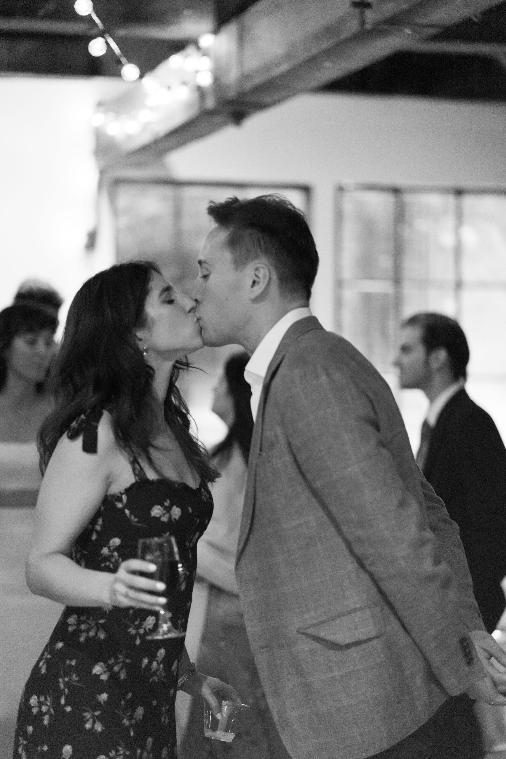 black and white image of a couple kissing on the dance floor during the reception