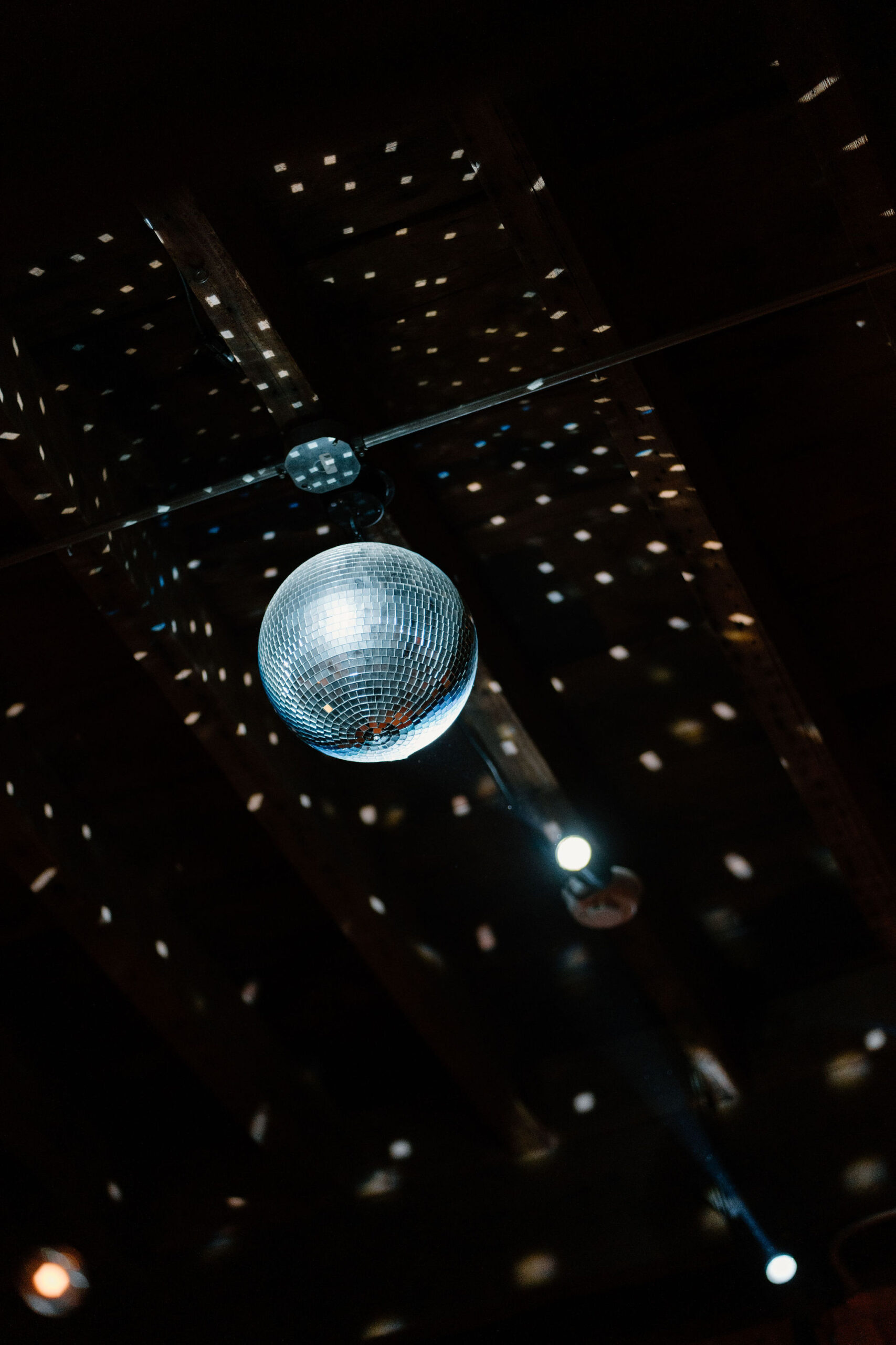 a disco ball in the rafters, reflecting sprays of light