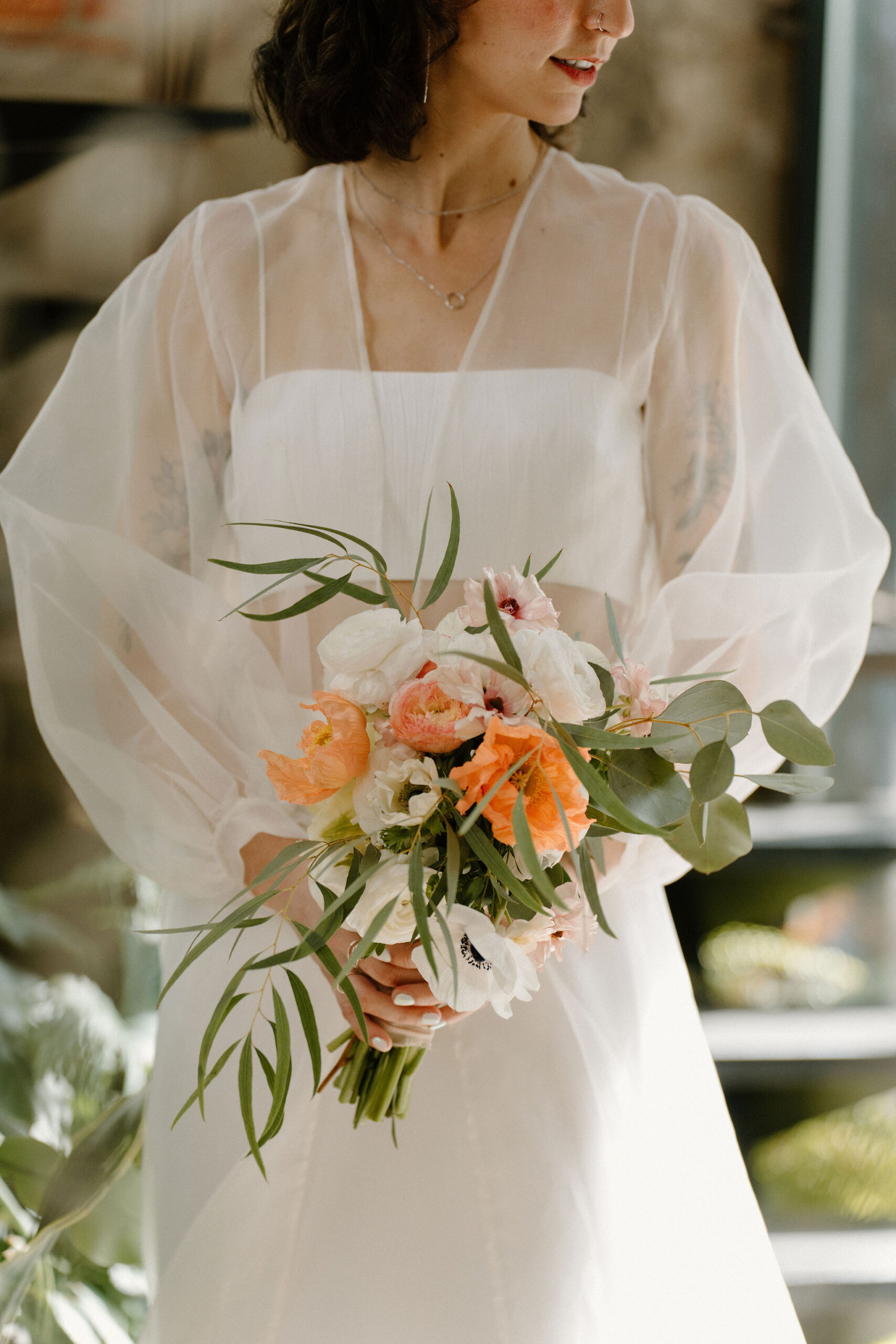 close up of a bride holding her bouquet, looking off to the side