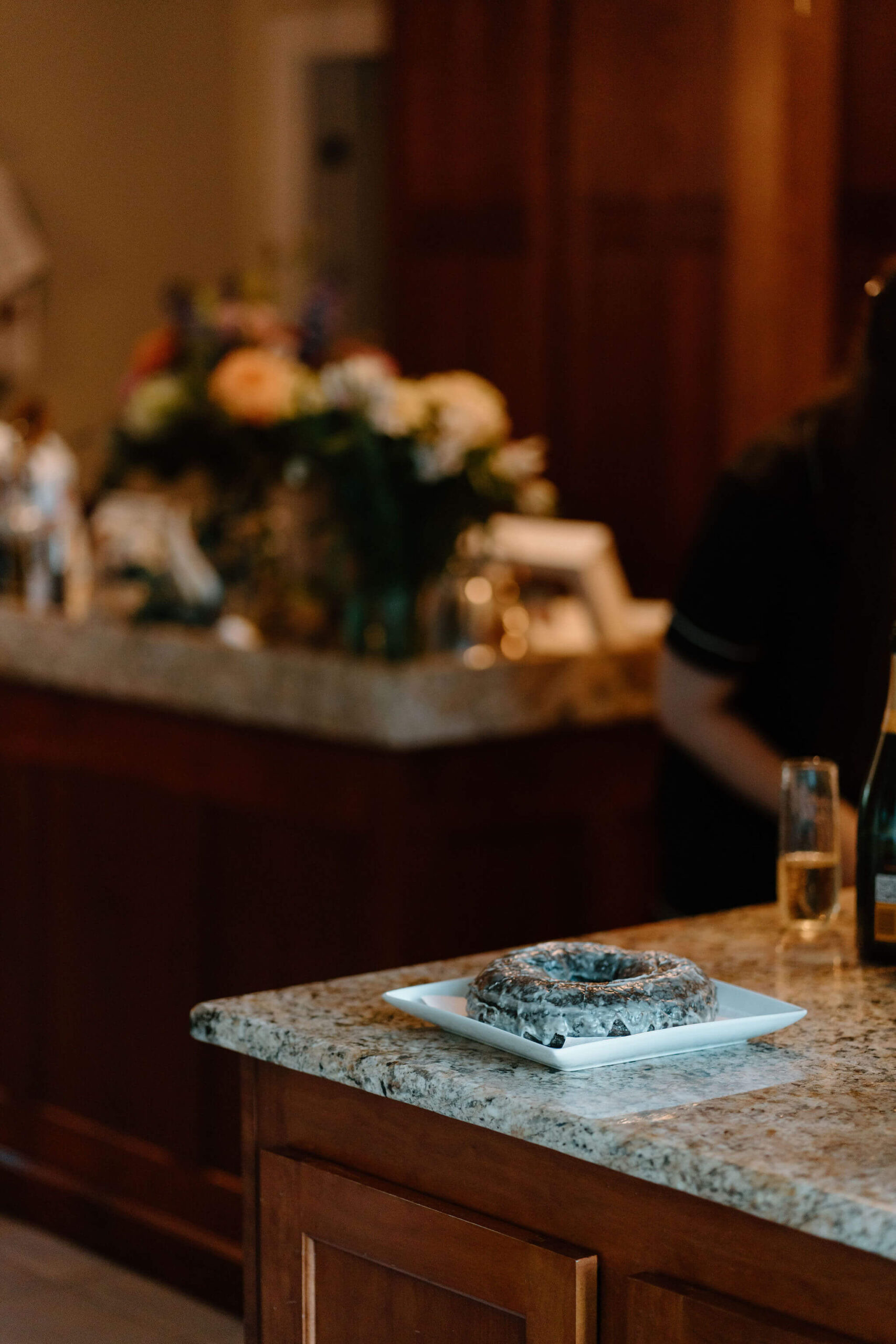 large chocolate doughnut on a plate, sitting on a kitchen counter