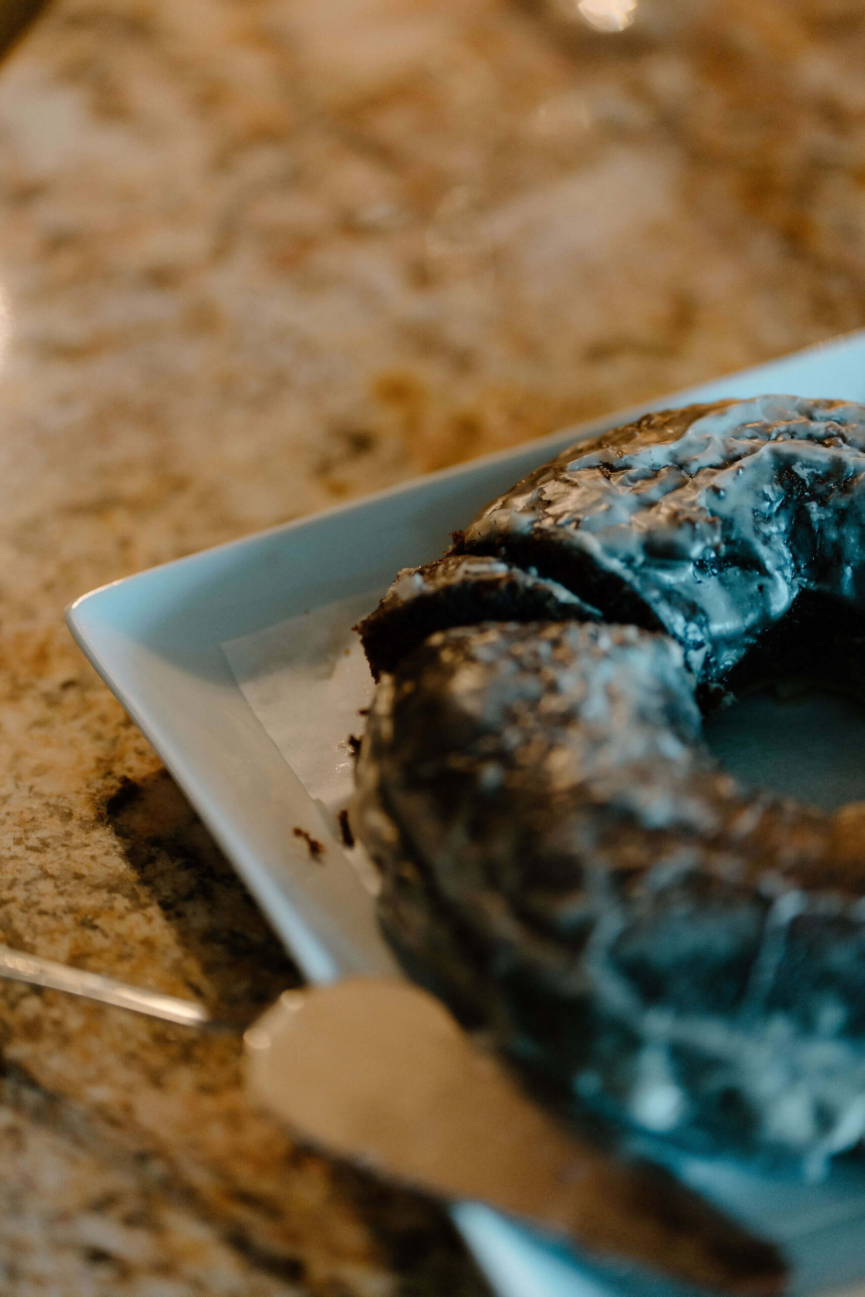 close up image of a slice taken out of a large chocolate donut