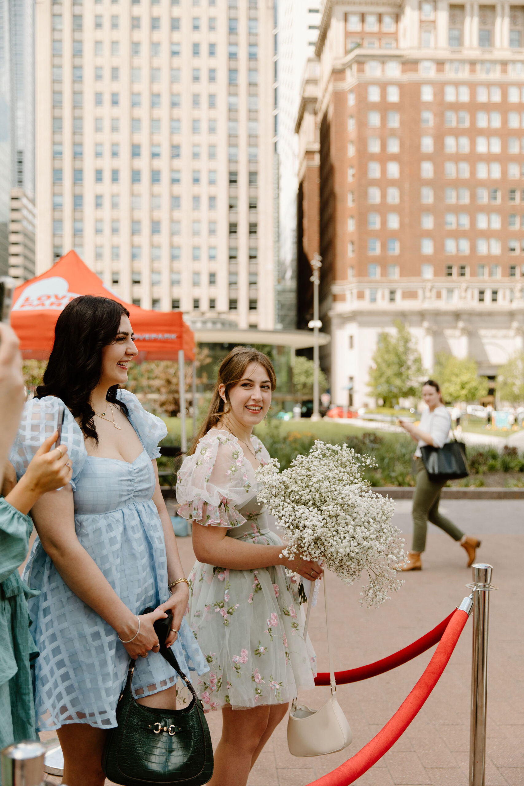 couples' sister, smiling and holding the bride's baby's breath bouquet