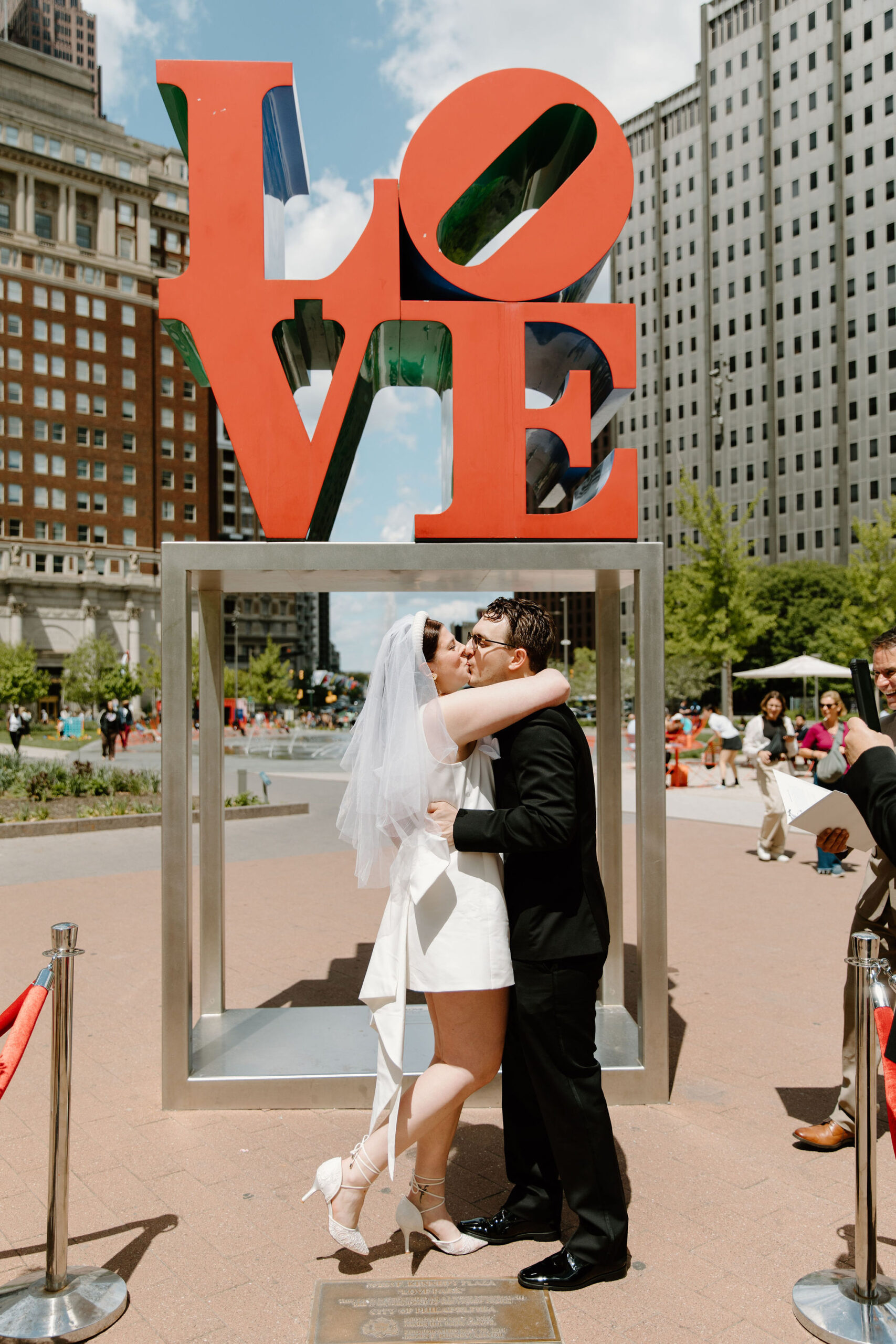 bride and groom's first kiss after their wedding ceremony in front of the Love Park sign in Philadelphia