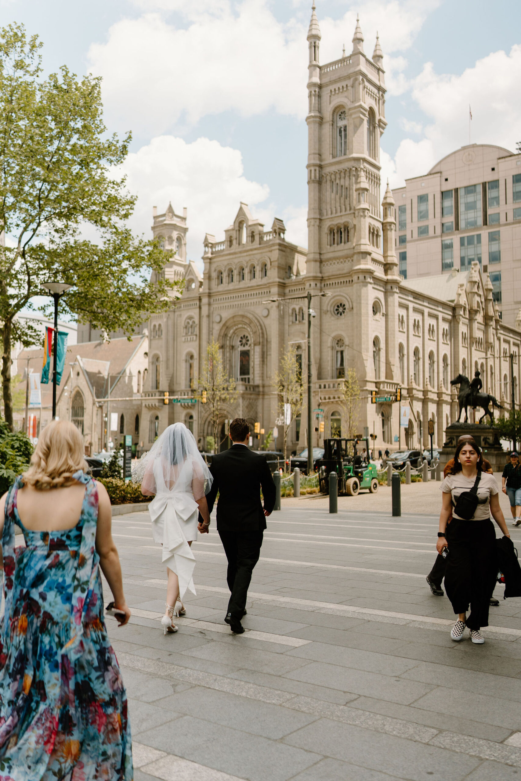 bride and groom walking near city hall, with One North Broad in the background