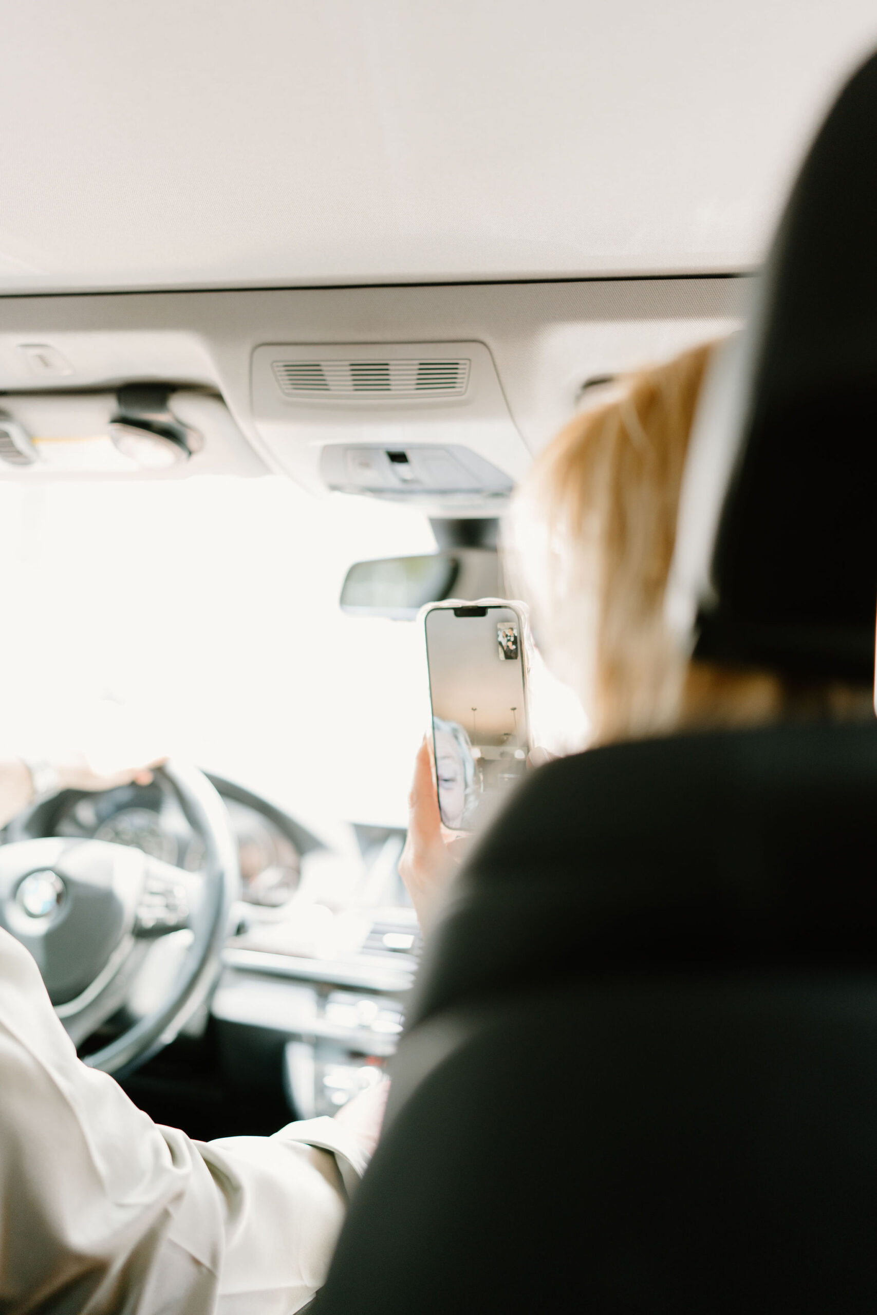 photo of bride's mother holding up her phone for her mother (the bride's grandmother) to FaceTime the bride & groom