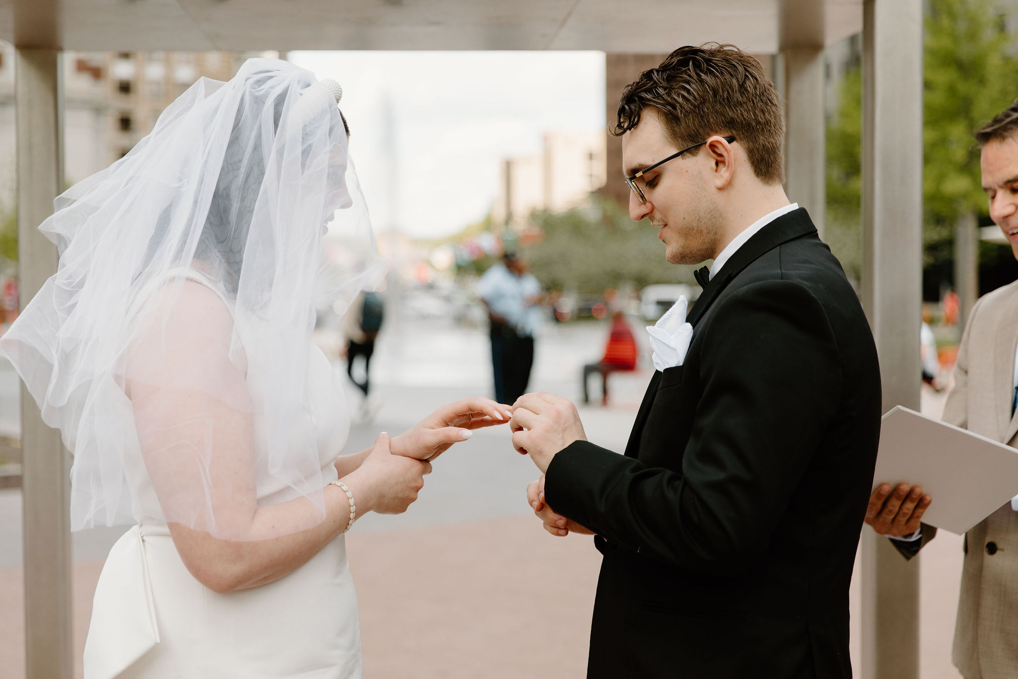 close up of bride and groom exchanging rings during wedding ceremony