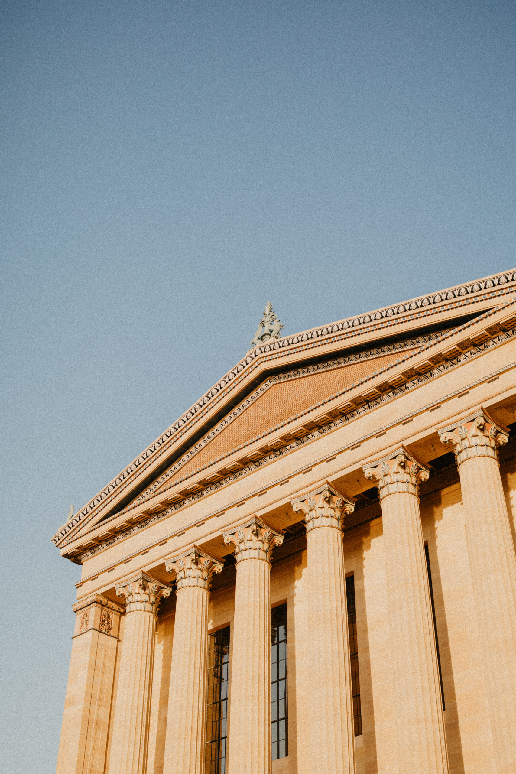 the pillars of the Philadelphia Museum of Art glowing in the sunset against a blue sky