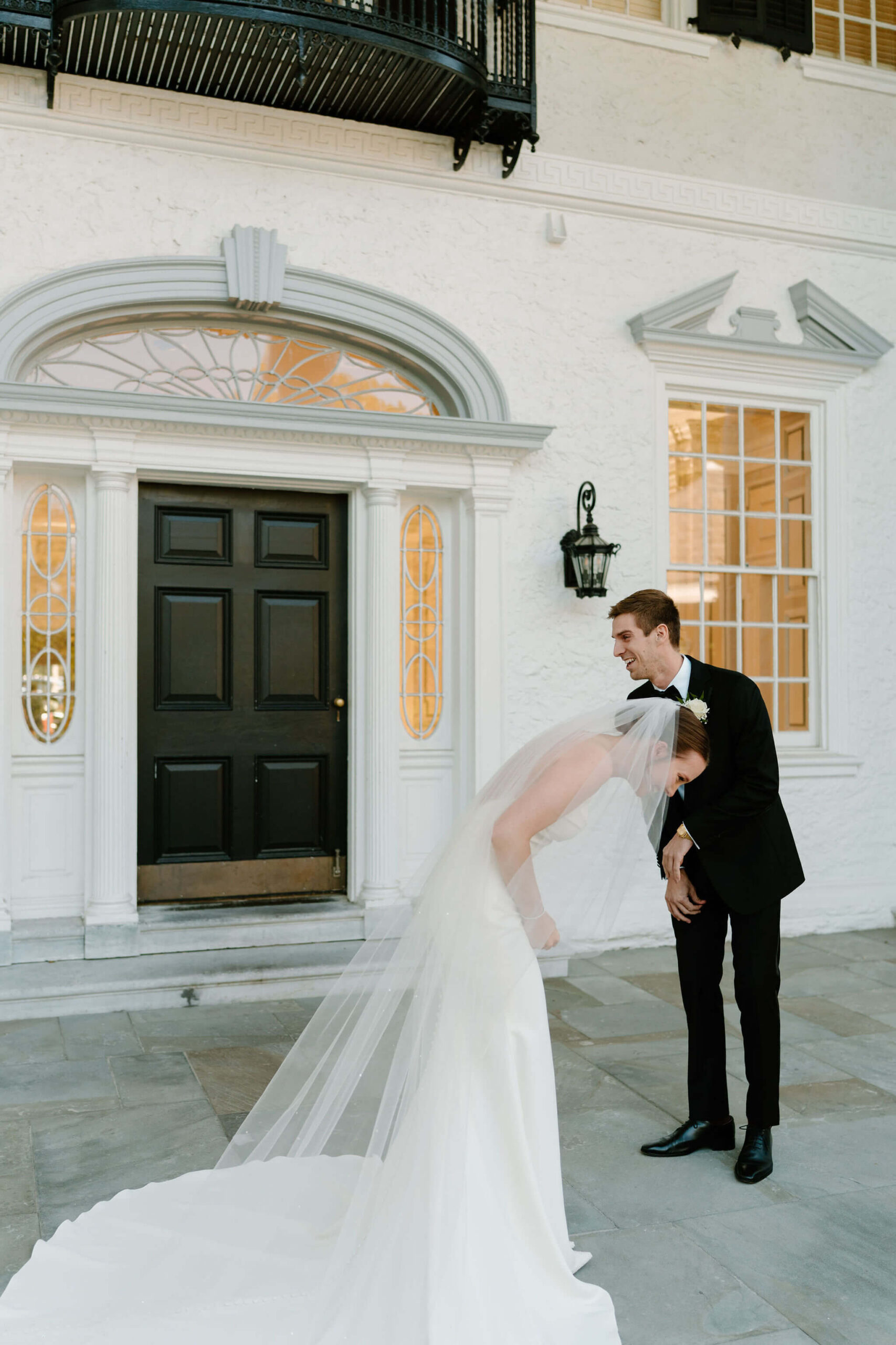 bride and groom both bent over laughing and crying during their first look on their wedding day