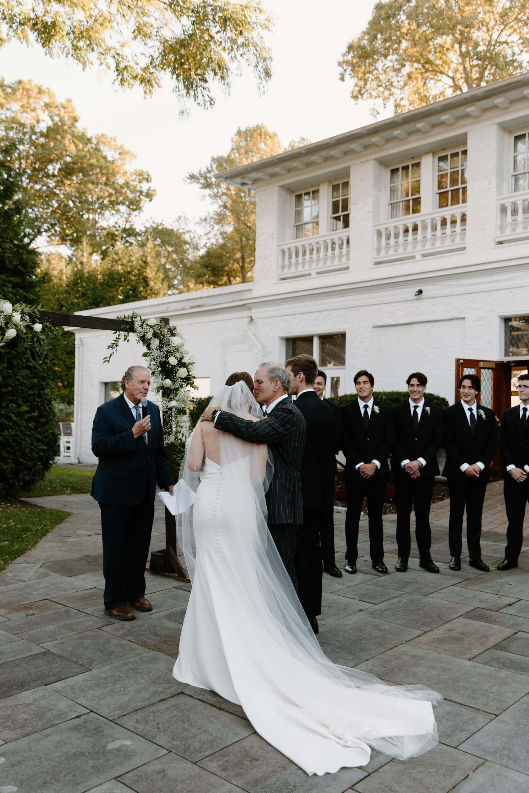 Father of the bride kissing his daughter on the cheek before giving her away during her wedding ceremony