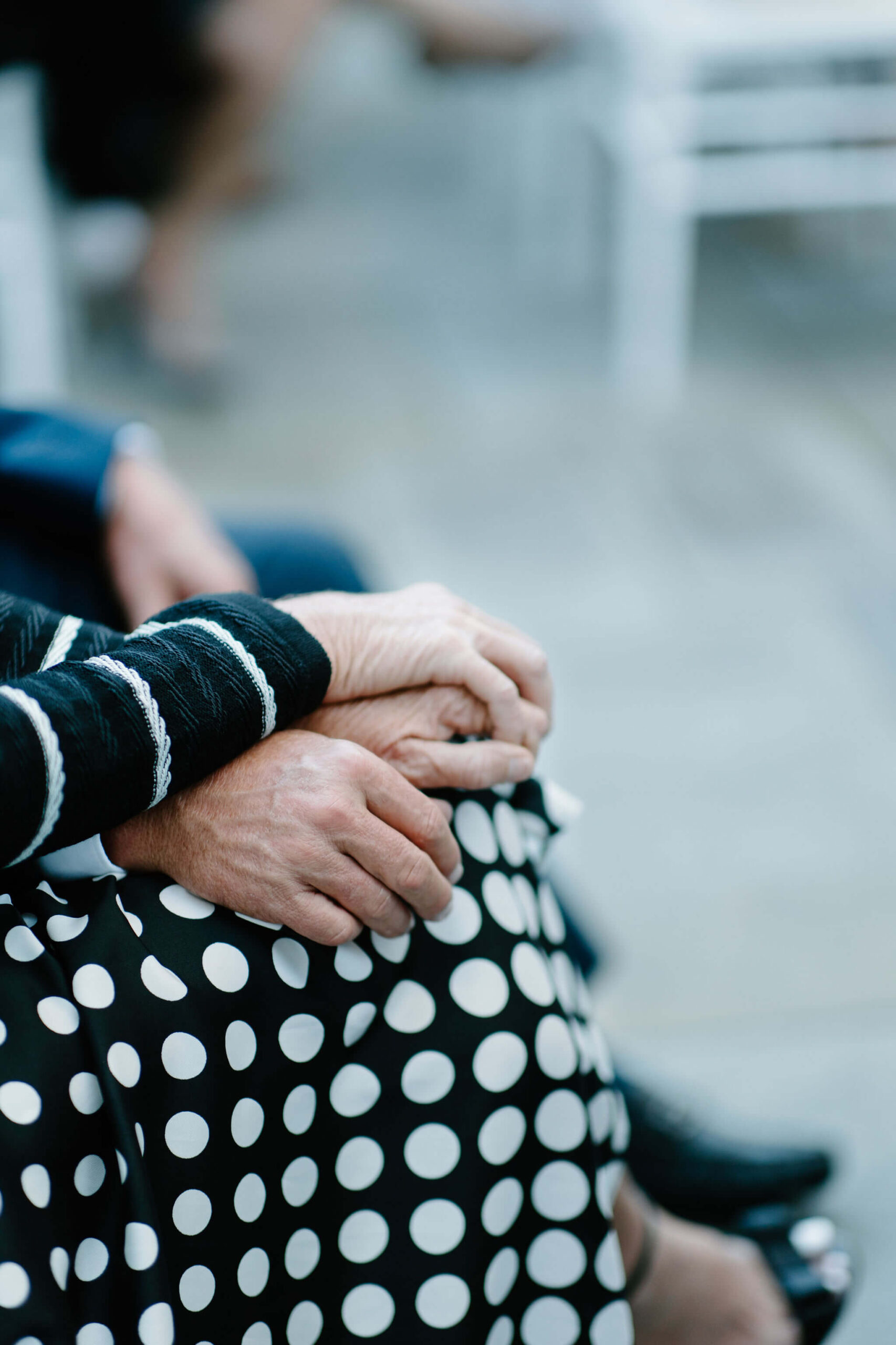 Close up image of two guests holding hands during a wedding ceremony