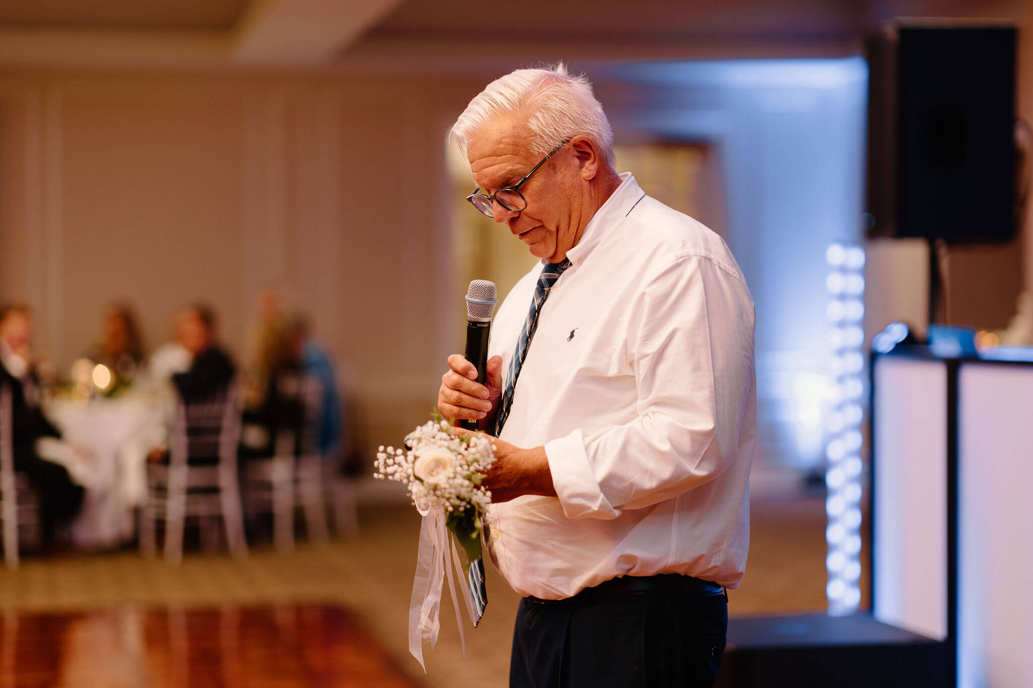 father of the groom giving a speech, holding a rose in honor of Ian's late mother