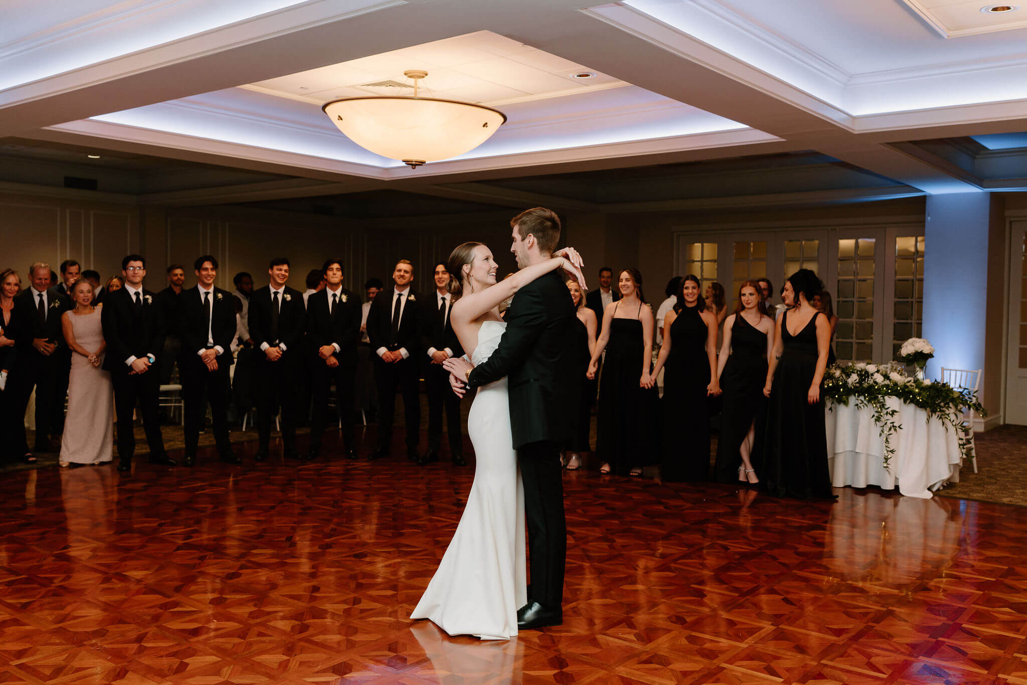 bride and groom's first dance on their wedding day, surrounded by their wedding party