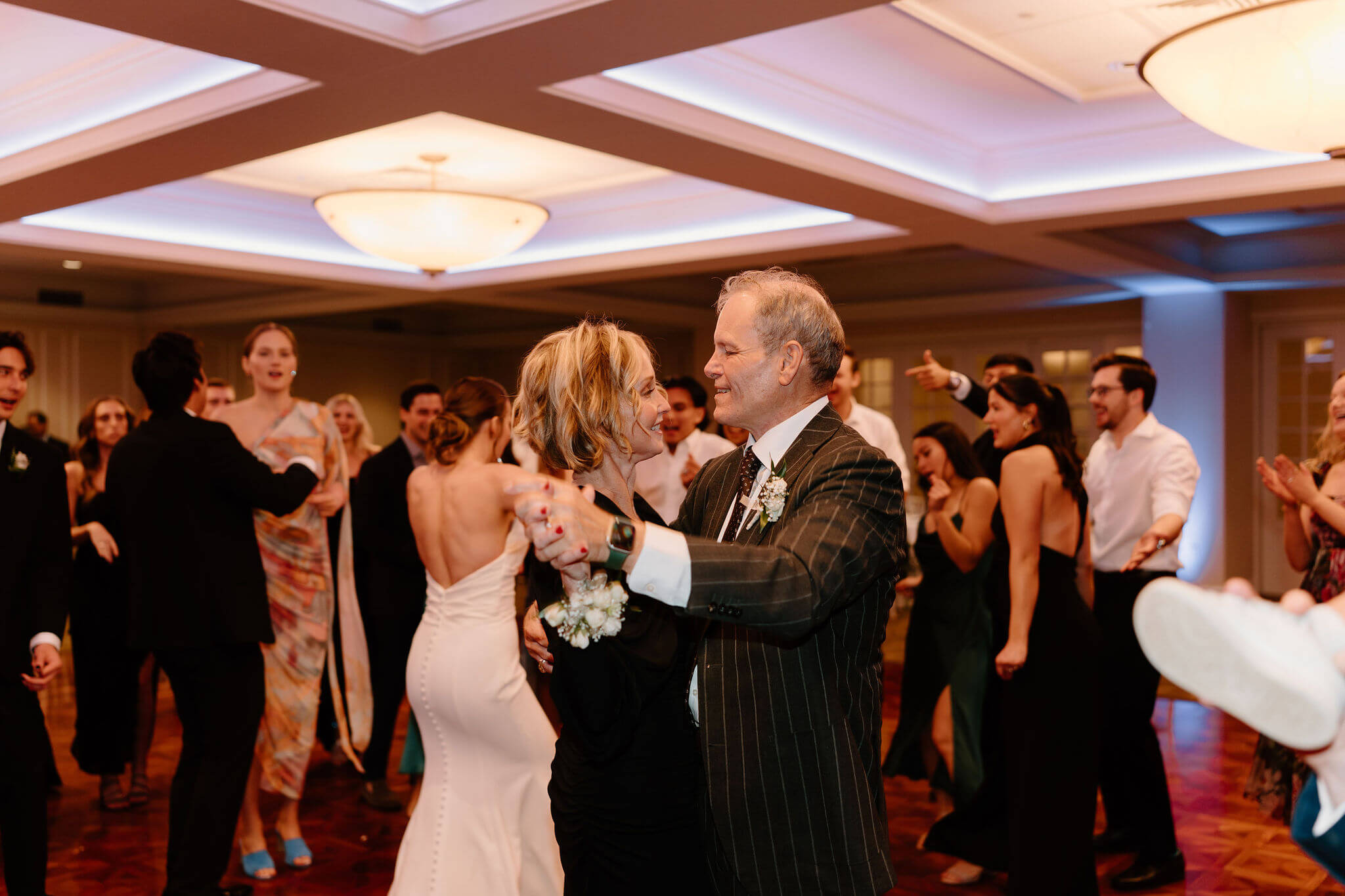 parents of the bride dancing together during their daughter's wedding reception, smiling softly at each other