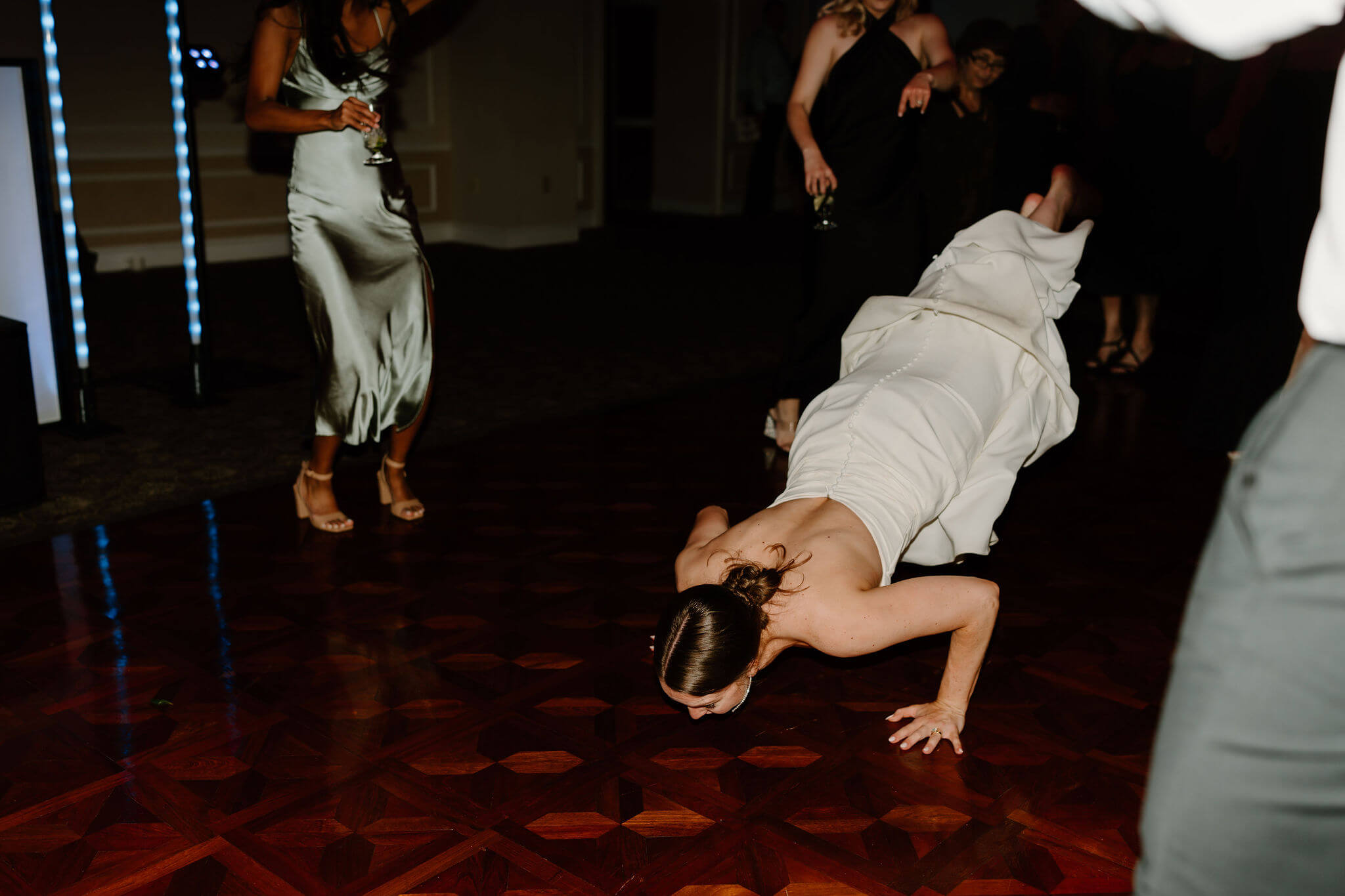 bride doing the worm in her wedding dress on the dance floor during her wedding reception at Radnor Valley Country Club in Philadelphia