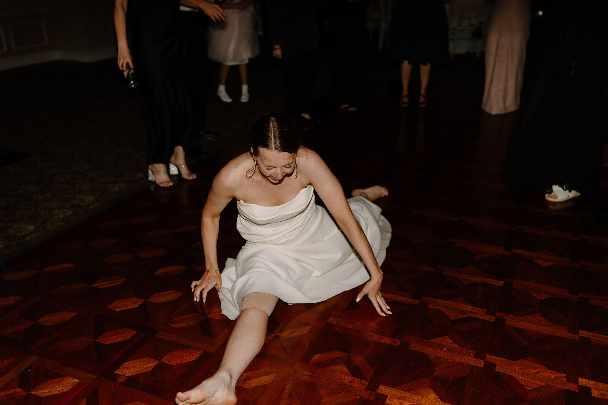 bride doing a split in her wedding dress on the dance floor at her wedding reception