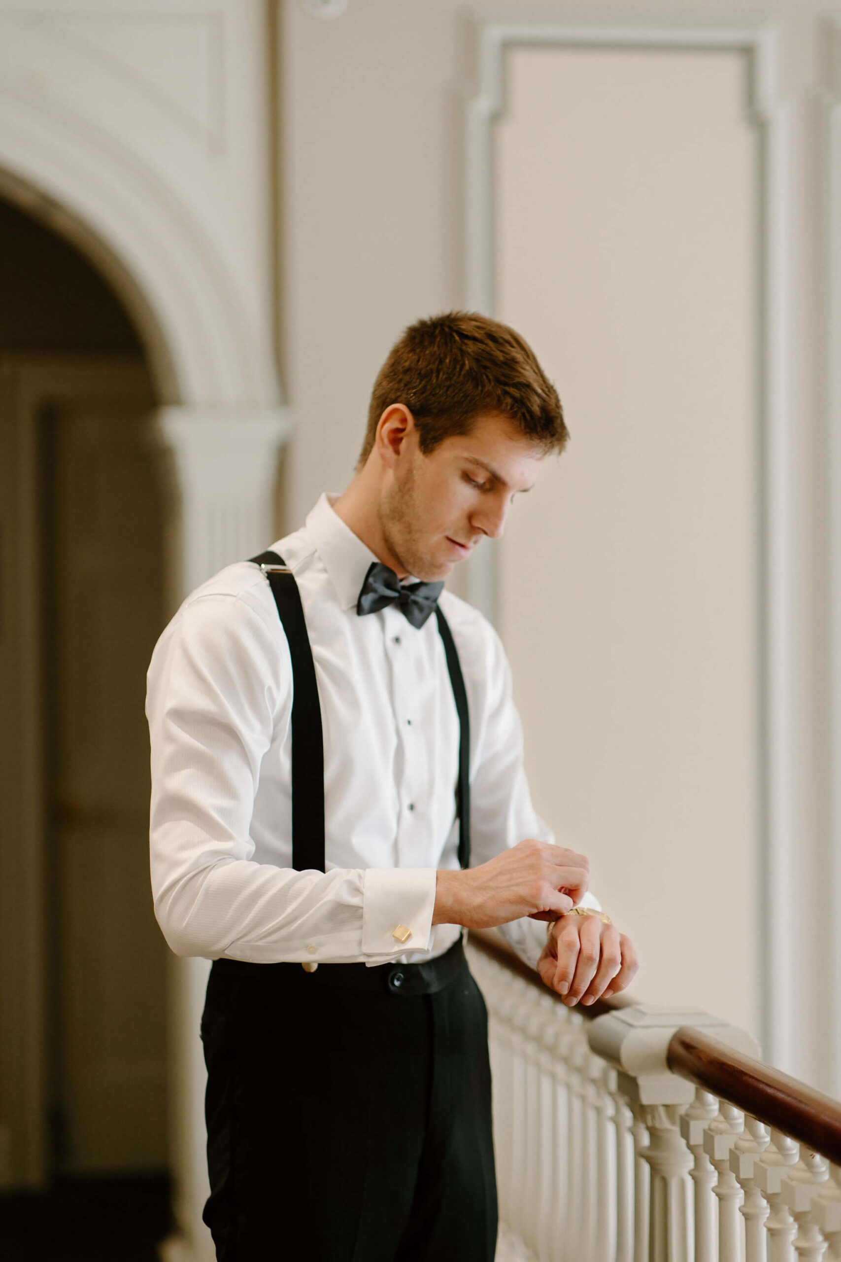 groom fixing his cuff links