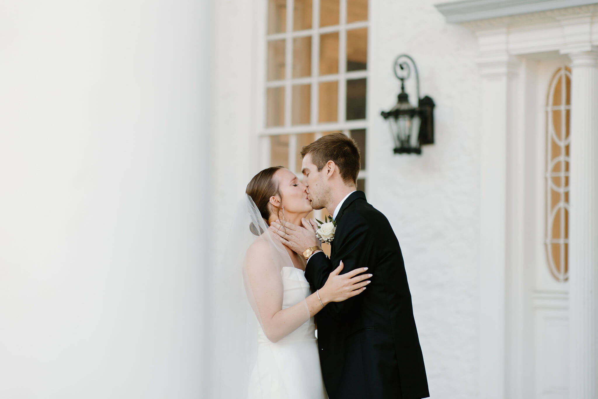 groom holding bride's face as they kiss during their first look