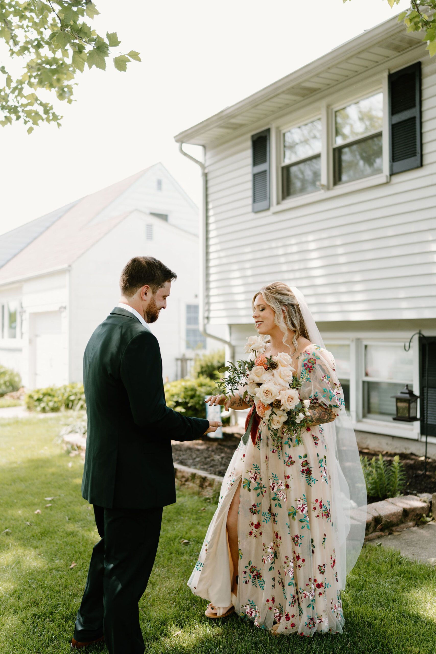 bride and groom's first look on their wedding day, smiling at each other as they see each others' outfits