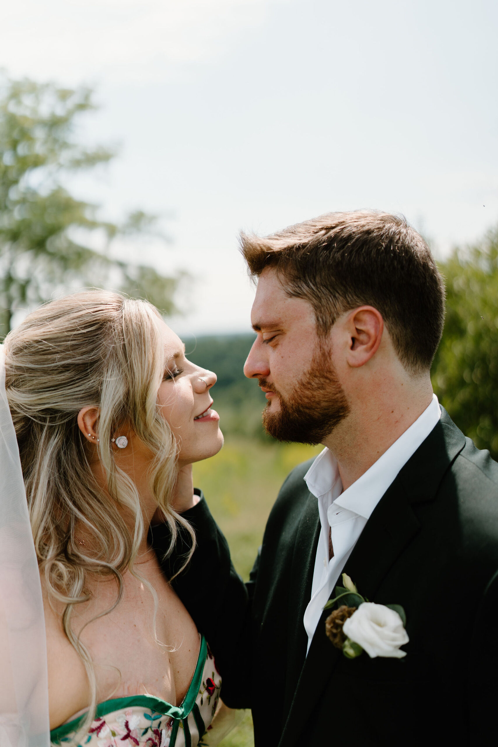 groom gently holding his bride's face on their wedding day, about to kiss her