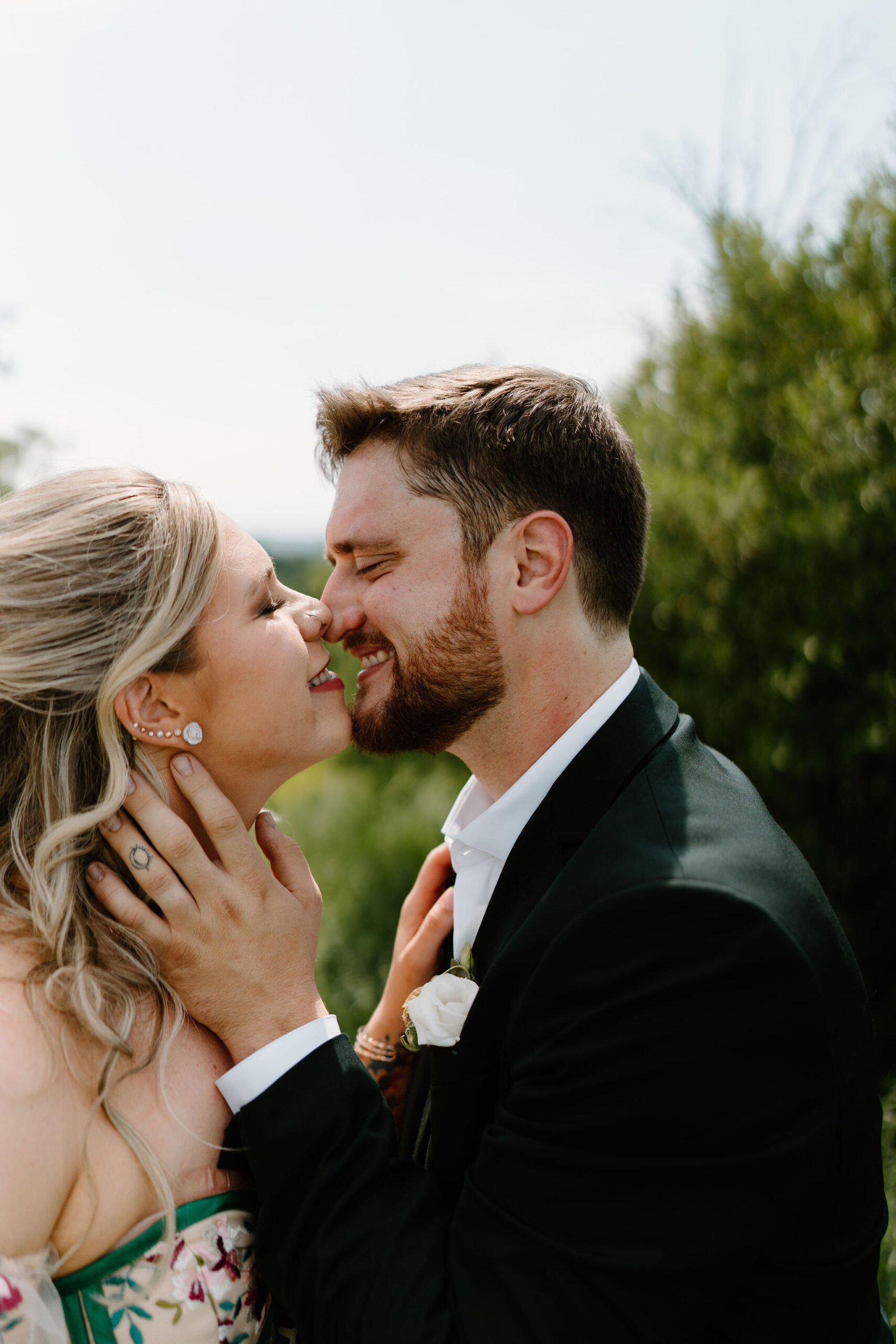 groom gently holding his bride's face on their wedding day, about to kiss her
