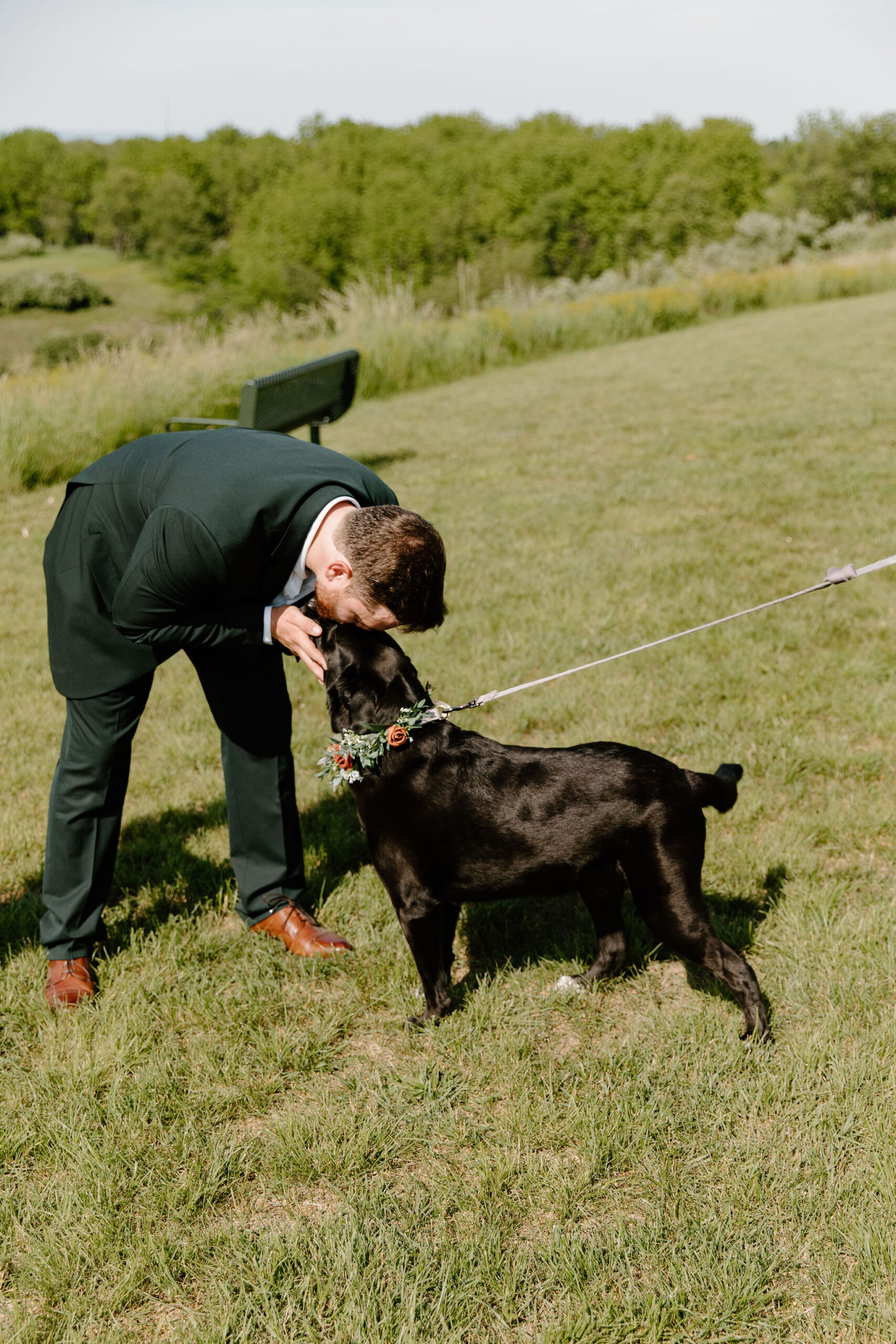 groom greeting his black lab at the end of the aisle for his wedding ceremony