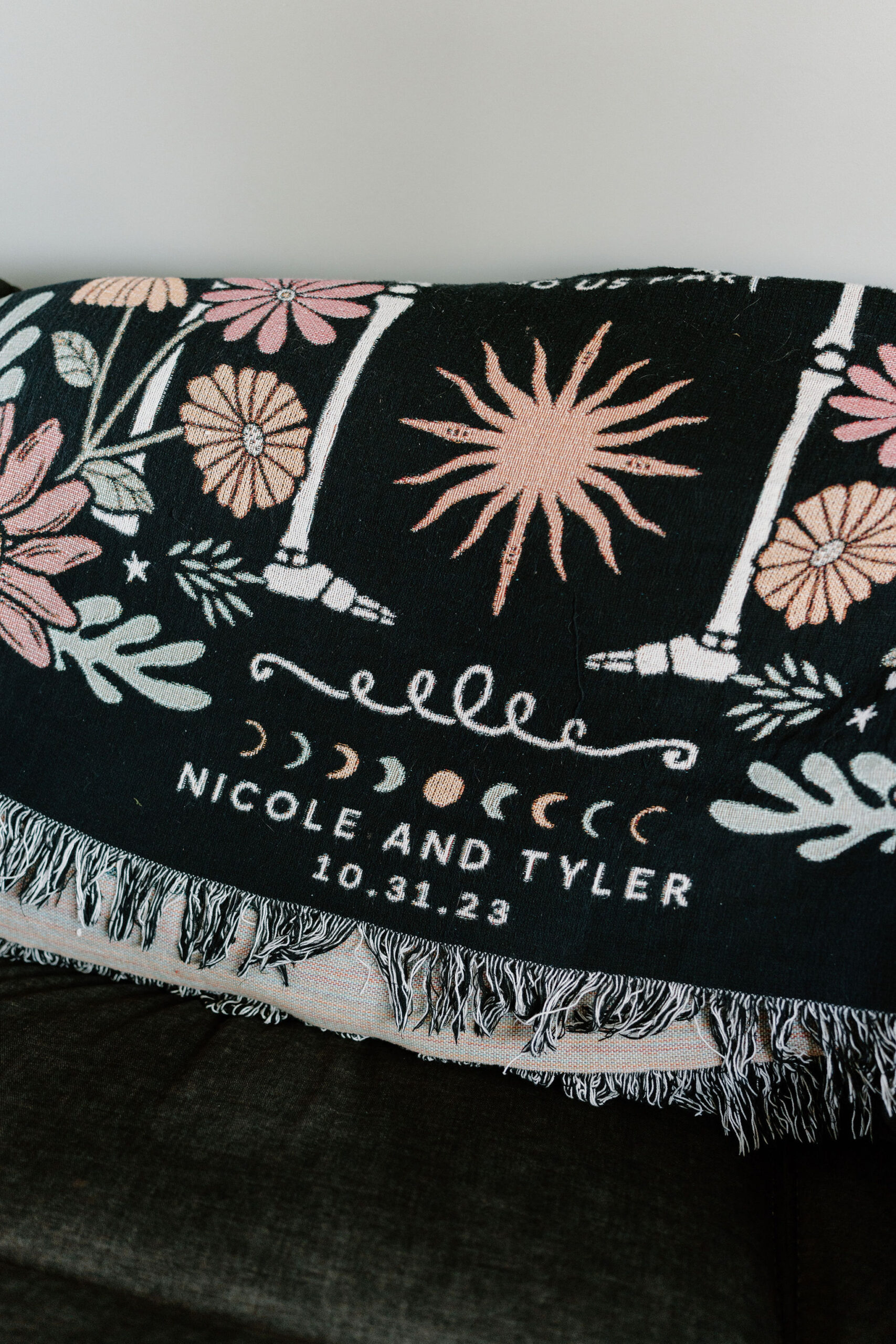 a custom blanket reading "Nicole and Tyler 10.31.23"