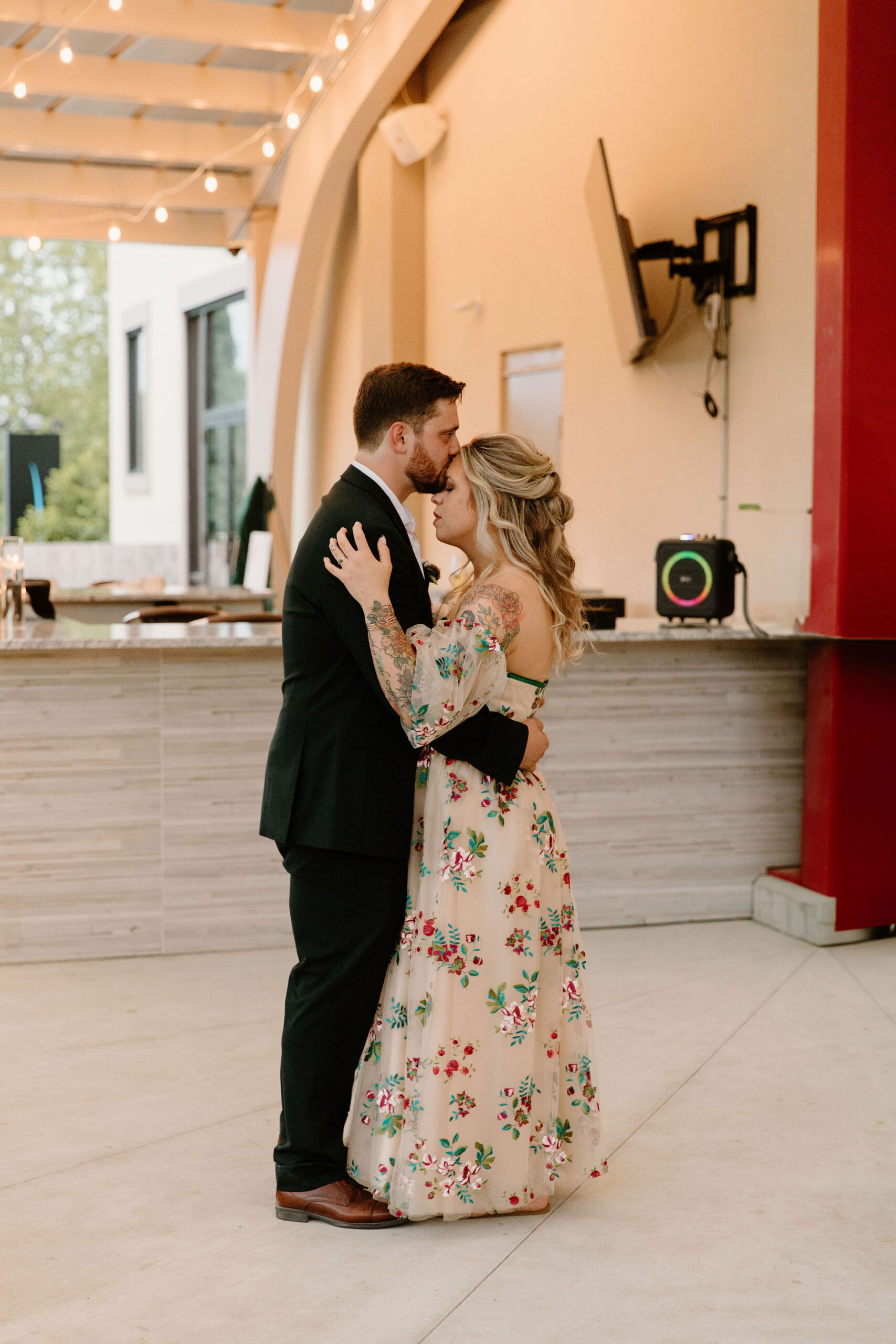 groom kissing bride on the forehead during their first dance