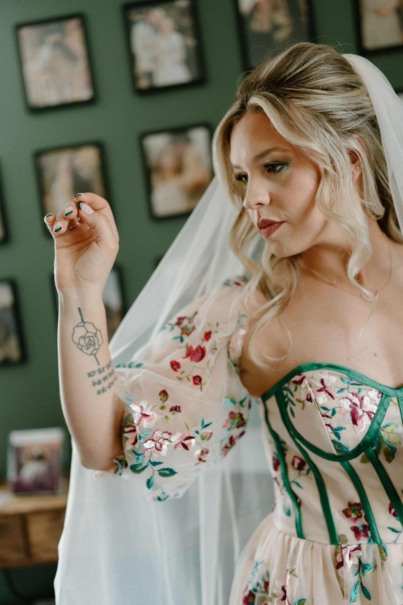 bride posing with her veil, looking over her right shoulder with one hand gracefully lifted