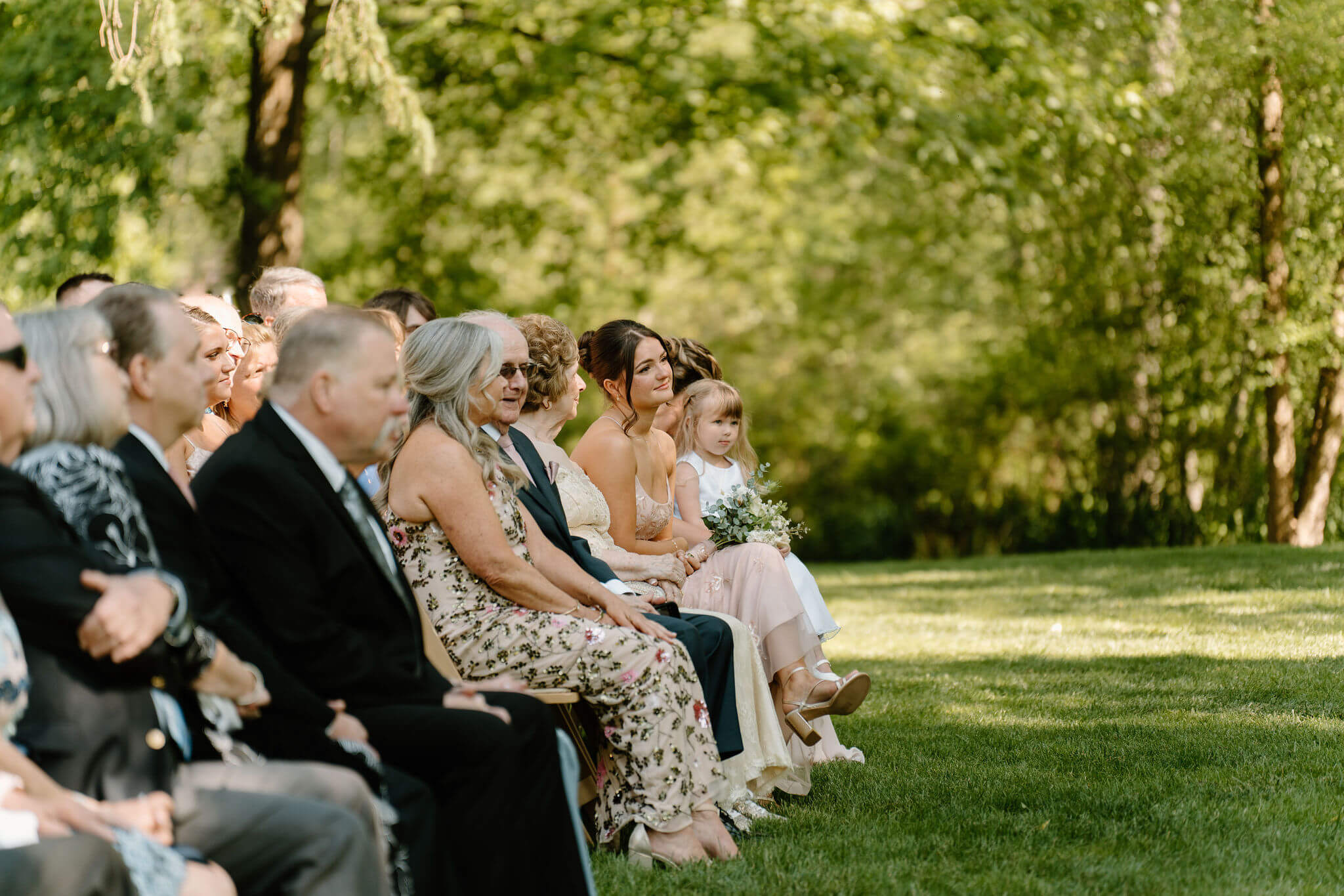 sister of the bride seated among guests, watching wedding ceremony