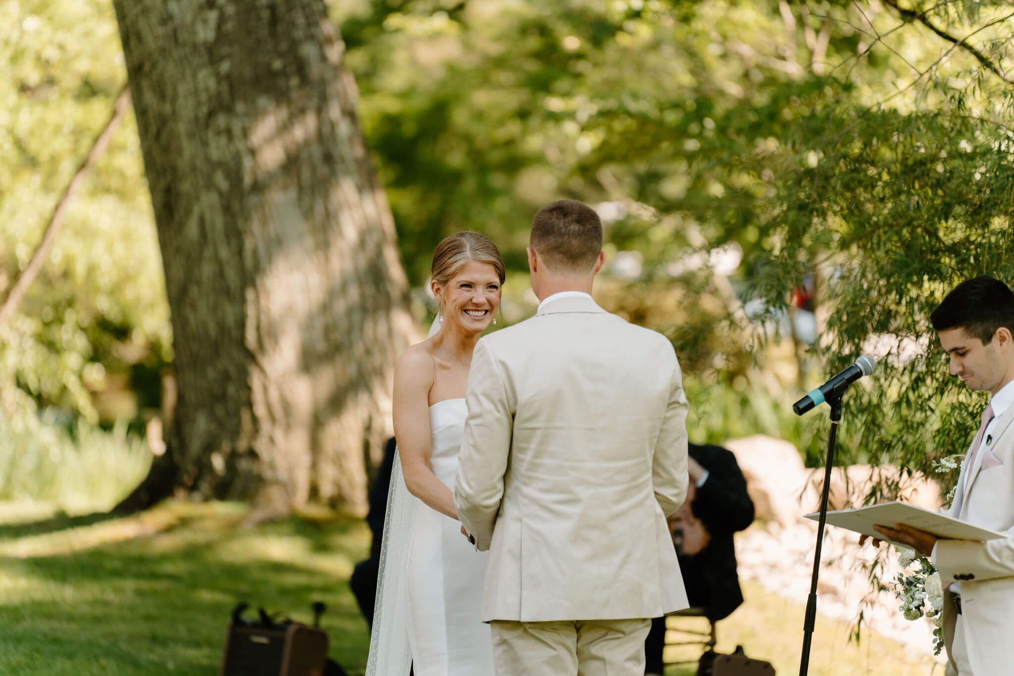 bride smiling at groom while holding hands during wedding ceremony
