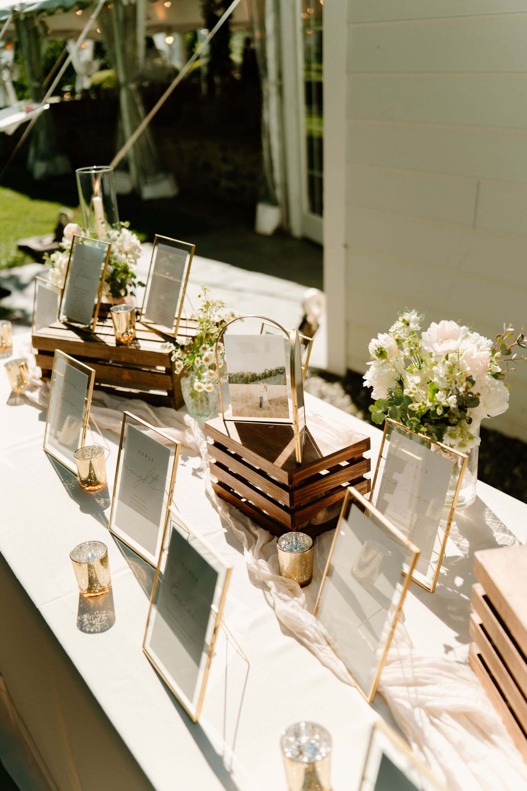 seating chart for wedding reception in gold frames on a long table