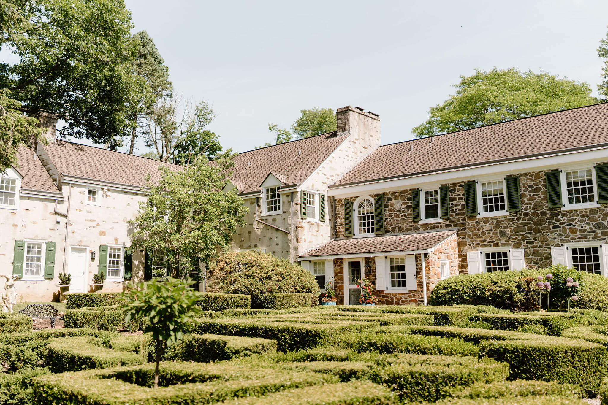 sprawling stone estate set behind a short hedge maze garden in Philadelphia suburbs
