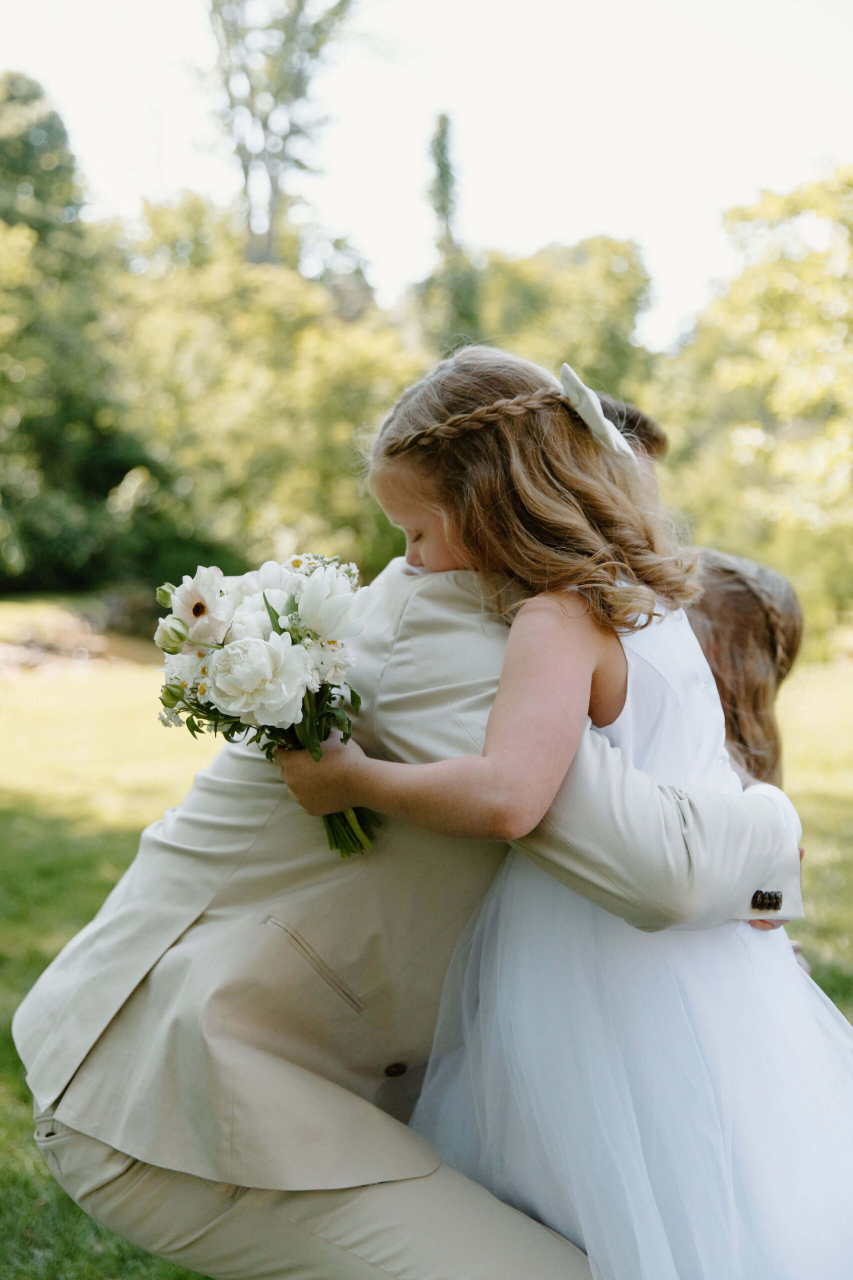 flower girl hugging groom, her uncle, at the end of the aisle during wedding ceremony
