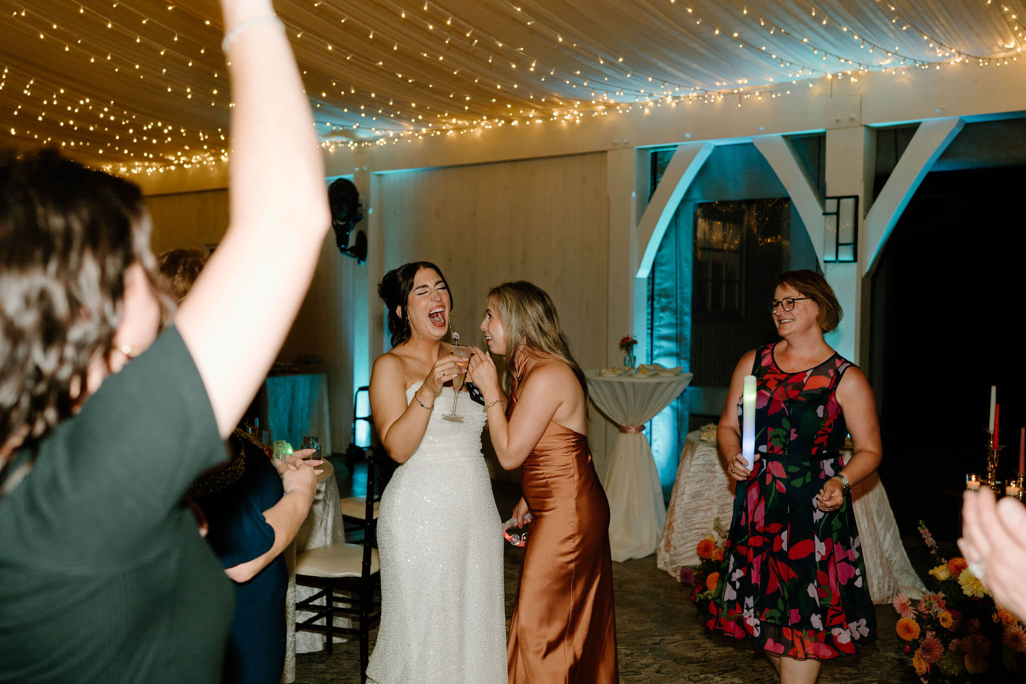 bride and friend laughing during wedding reception